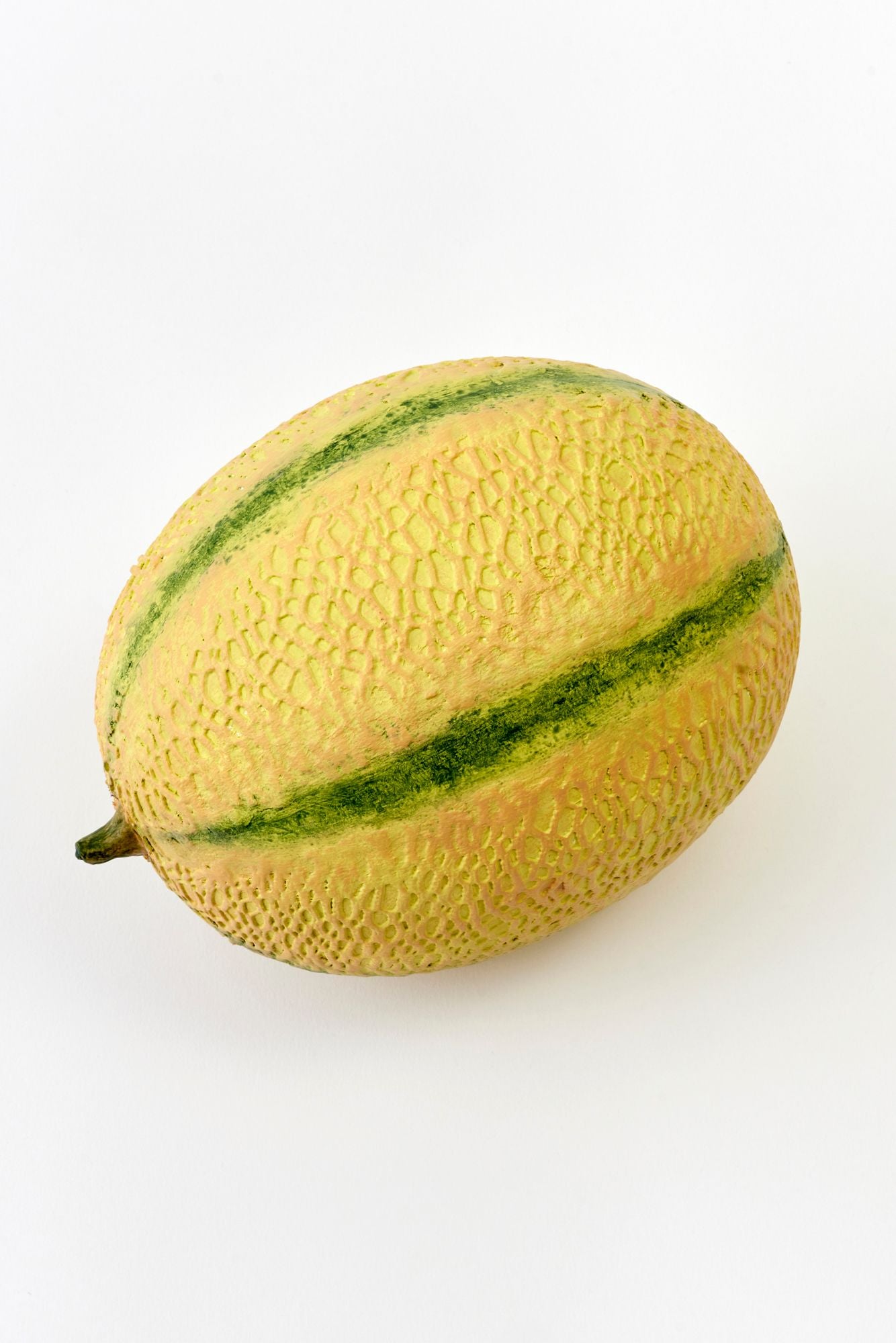 Yellow cantaloupe with green stripes on a white background