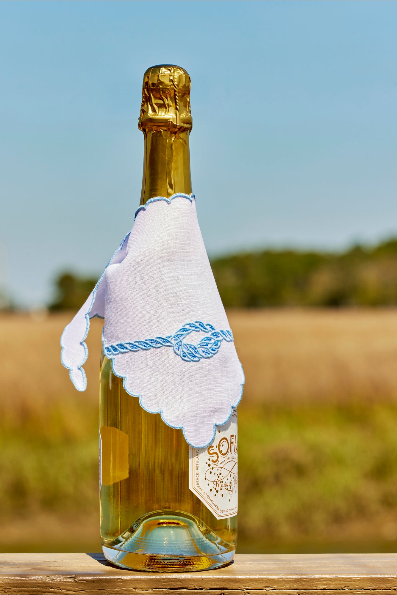 White bottle wrap with a blue knot.