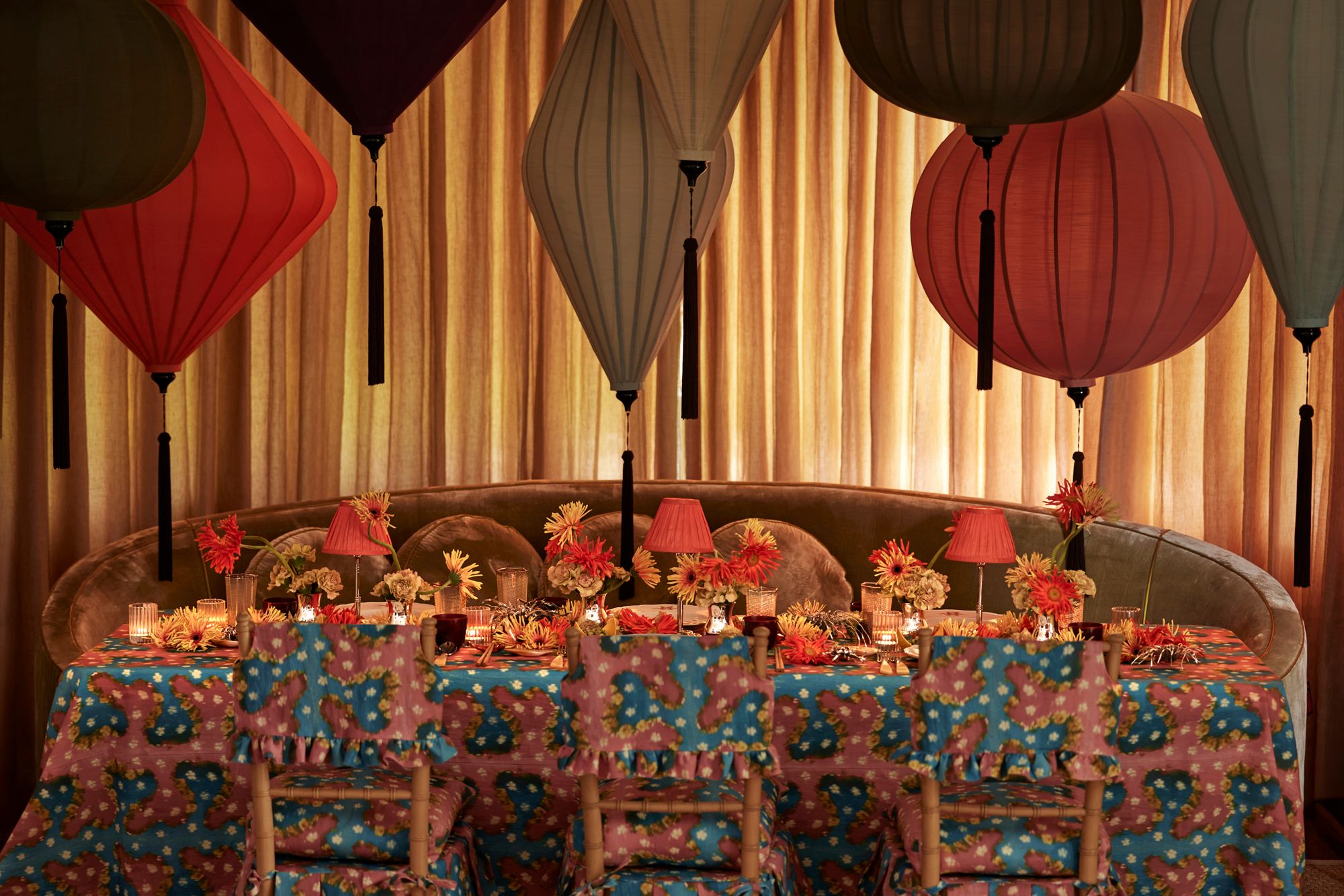 Decorative table setting with red and gray lanterns against a curtain backdrop