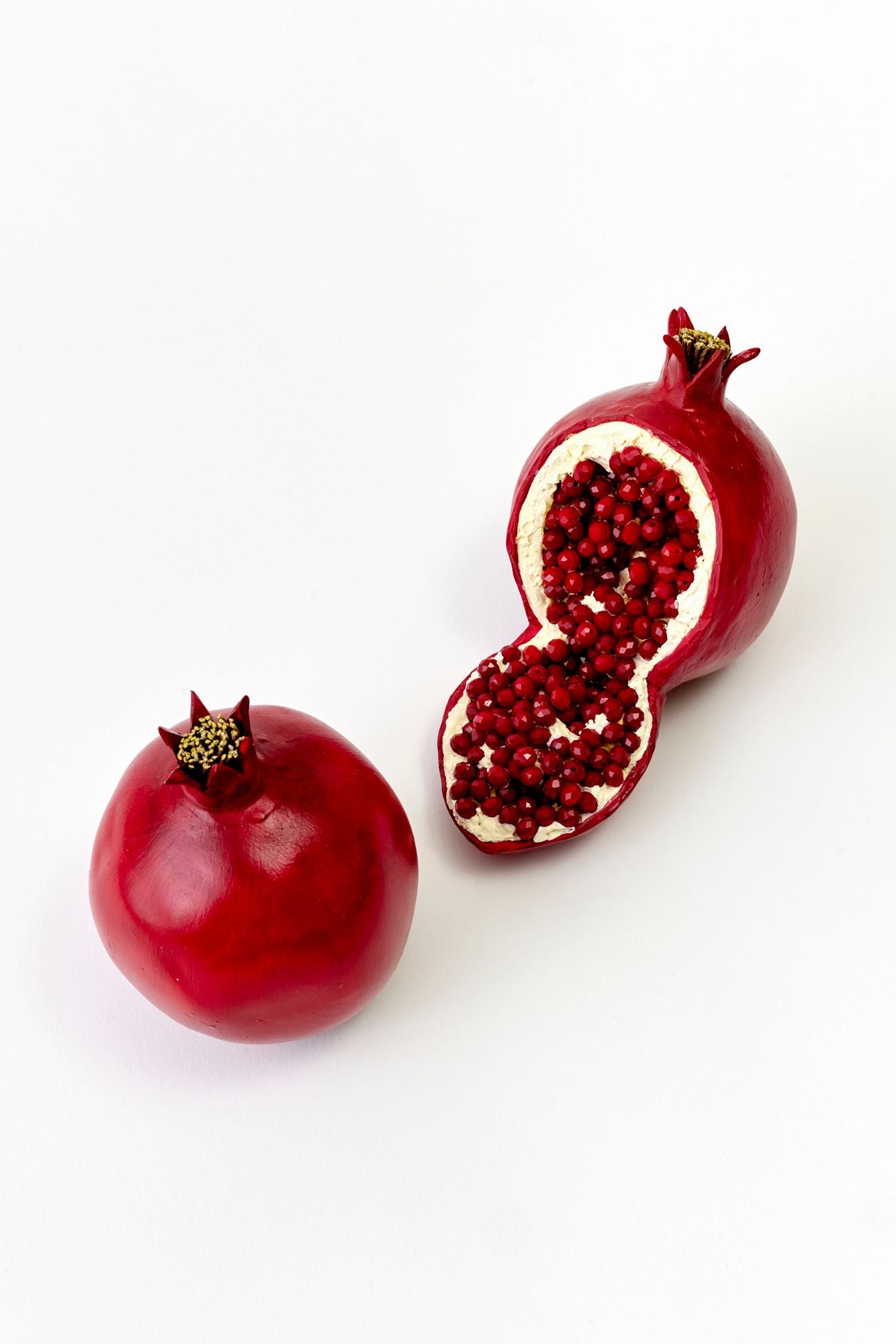 Pomegranate and a halved pomegranate on a white background