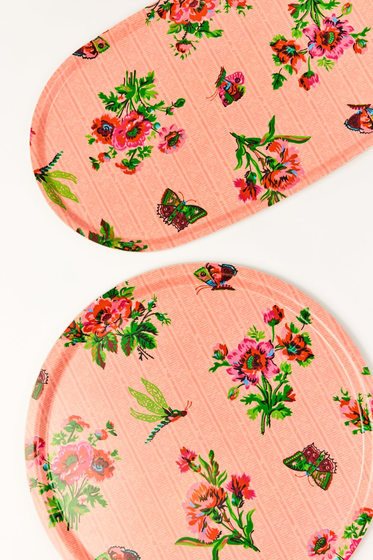 Two floral-patterned pink laminated trays with butterflies and flowers on a white background.