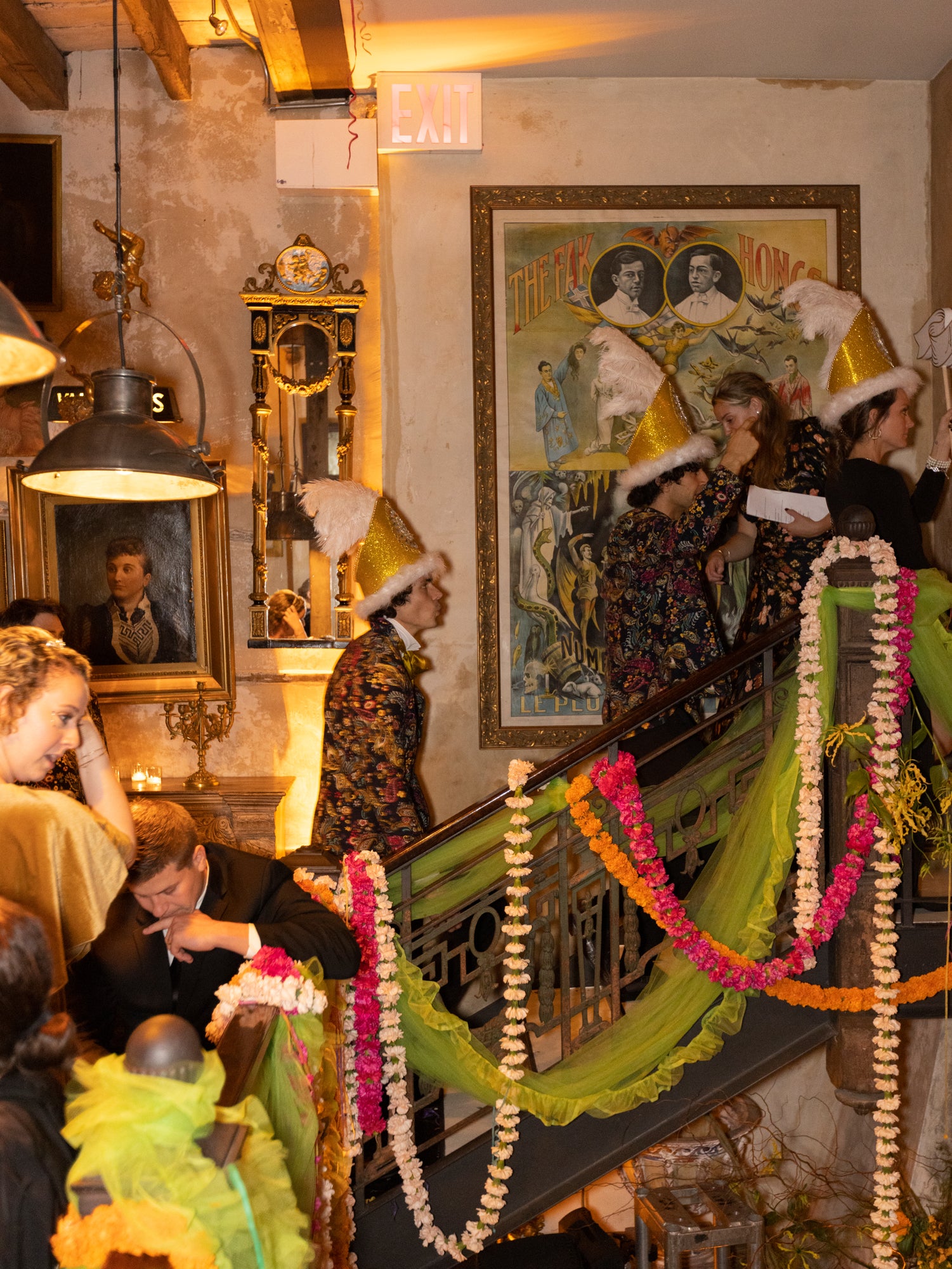 Crowd of people moving up and down stairs adorned with colorful marigold chains at a new york wedding.