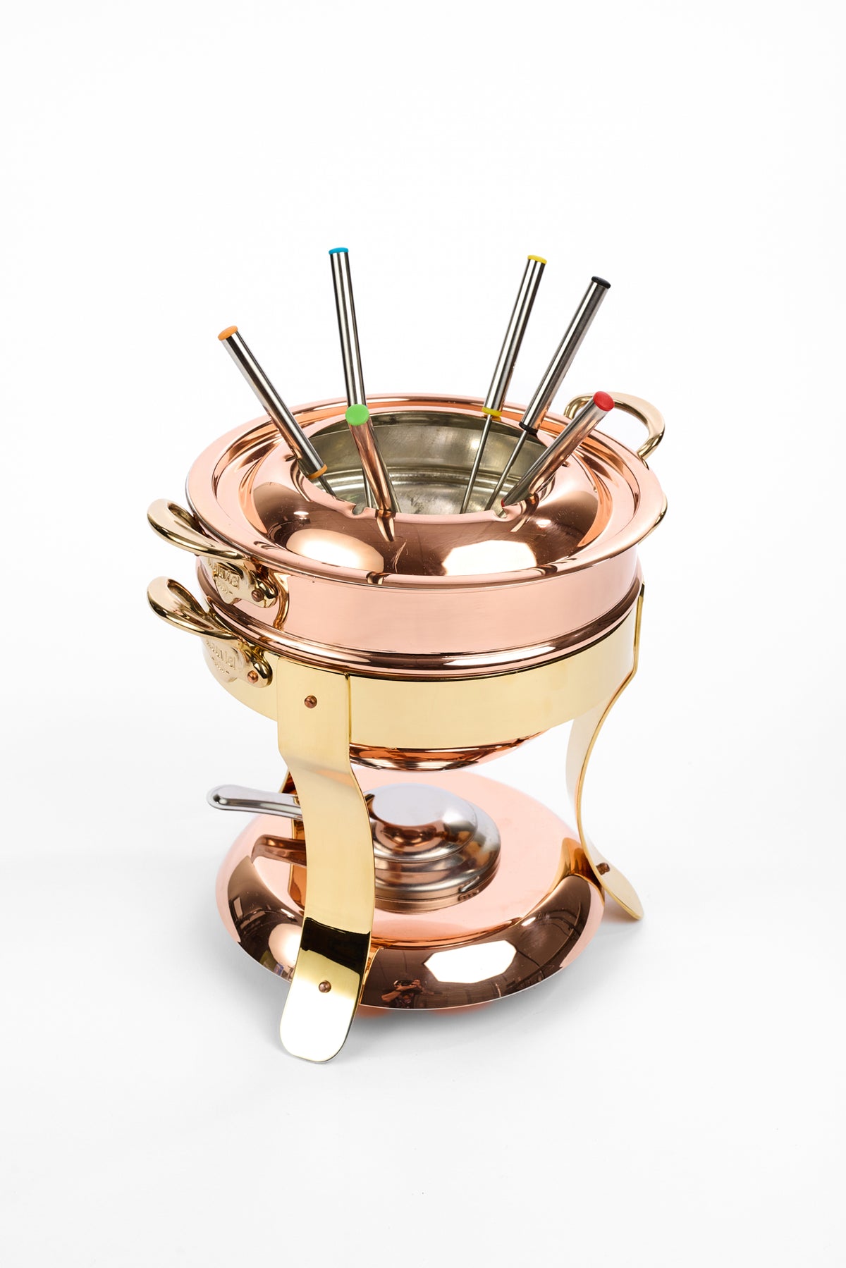 A copper and gold-colored copper fondue set with a matching copper pot, base, and handles, featuring several metal skewers with colored tips resting inside on a white background.