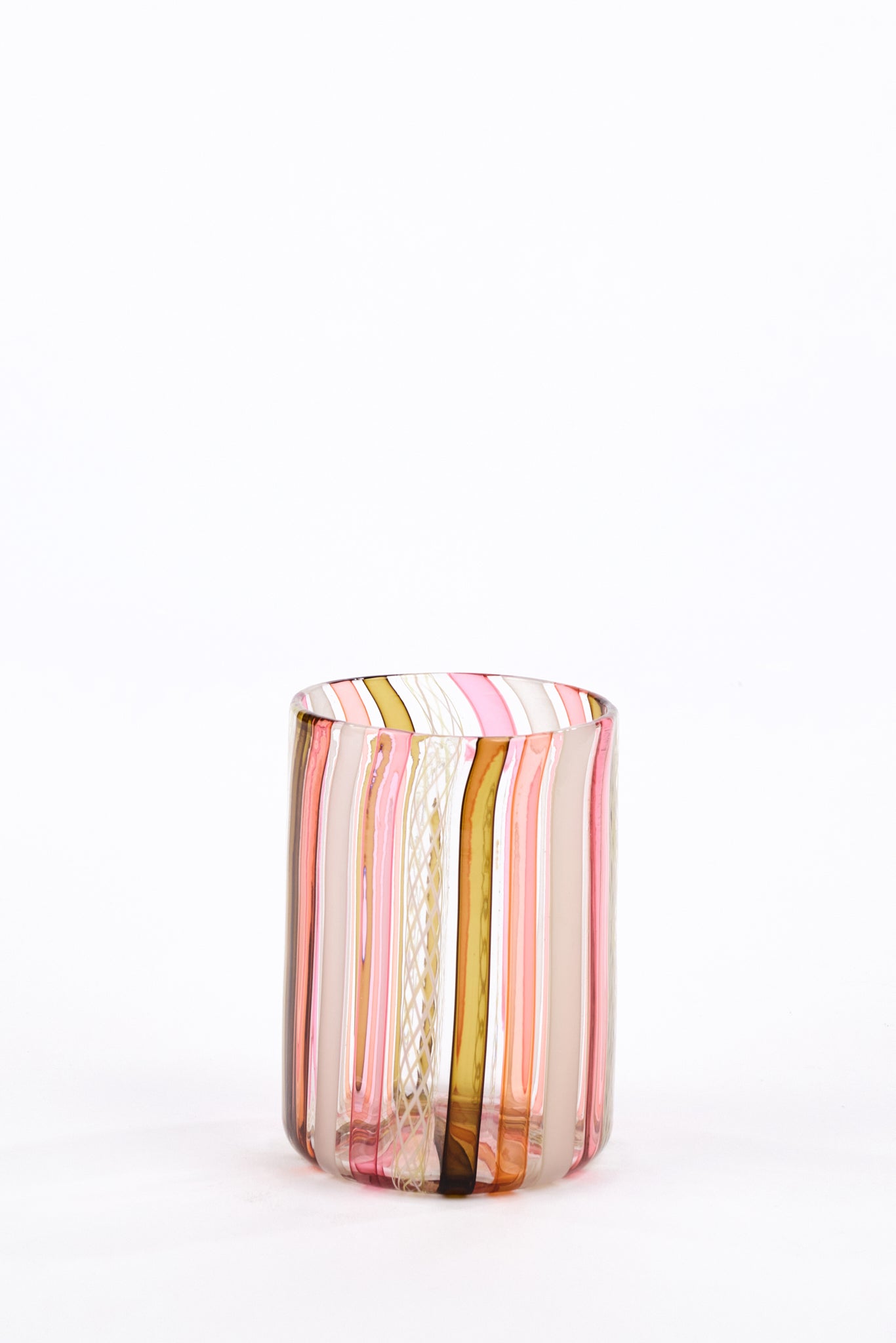 A small cylindrical glass tumbler with vertical hand-blown stripes in pink, white, and dark olive green, set against a seamless white background.