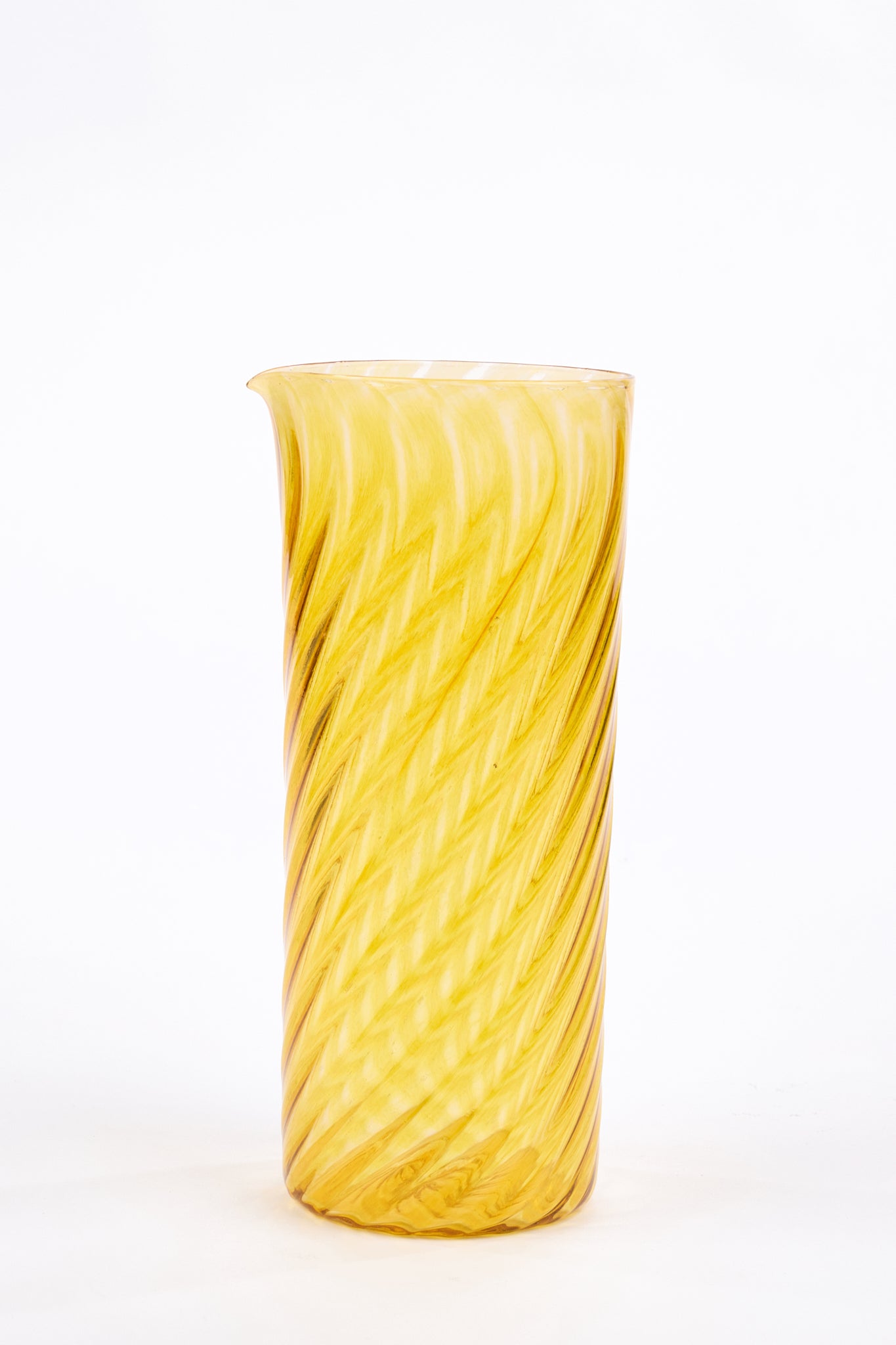 A tall, cylindrical yellow glass pitcher with a spiral twist pattern, photographed against a seamless white background.