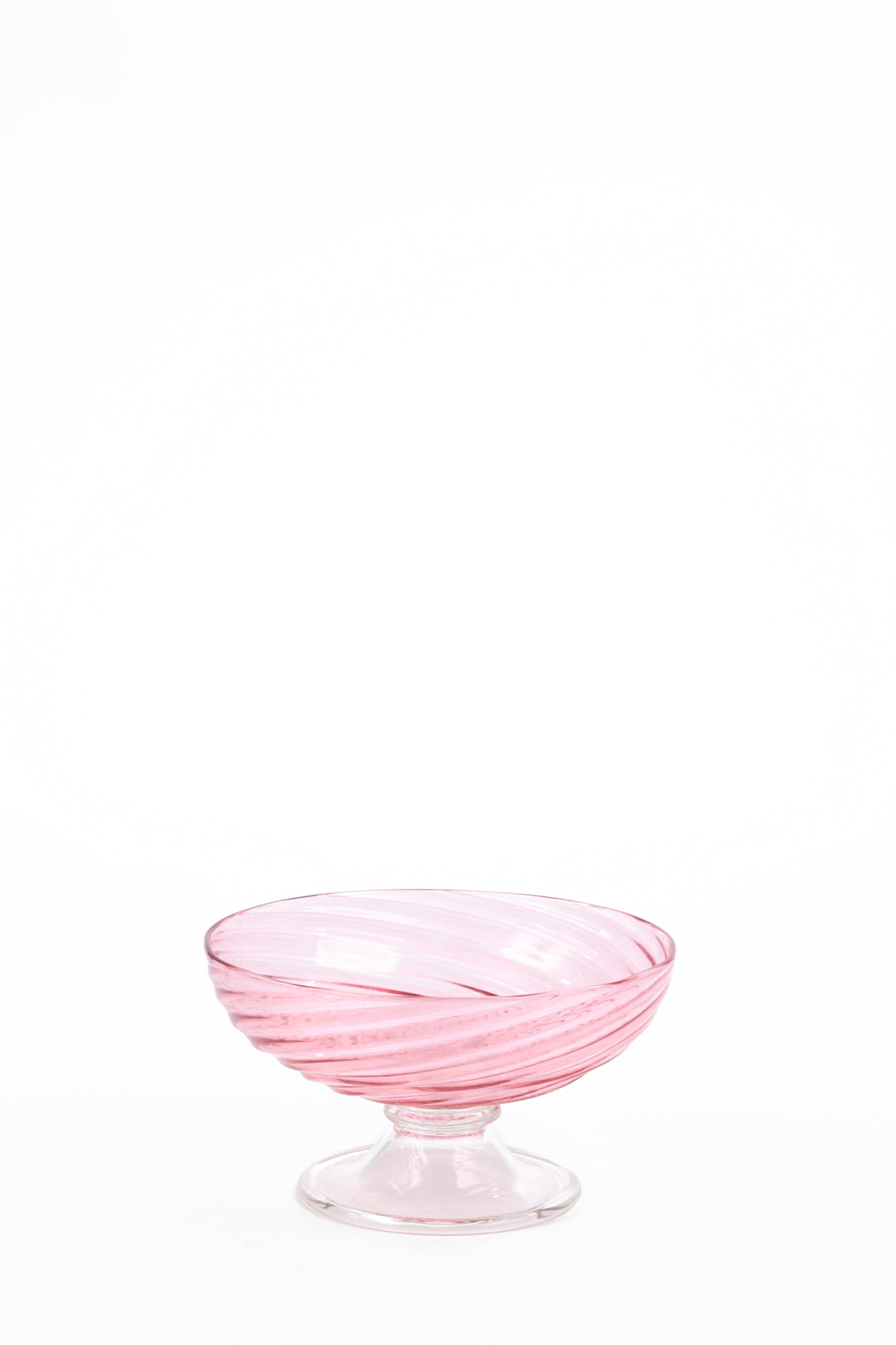 Pale pink glass compote with a wide, shallow bowl, short stem, and round foot. Translucent pink bands spiral around the bowl from the base to the rim.