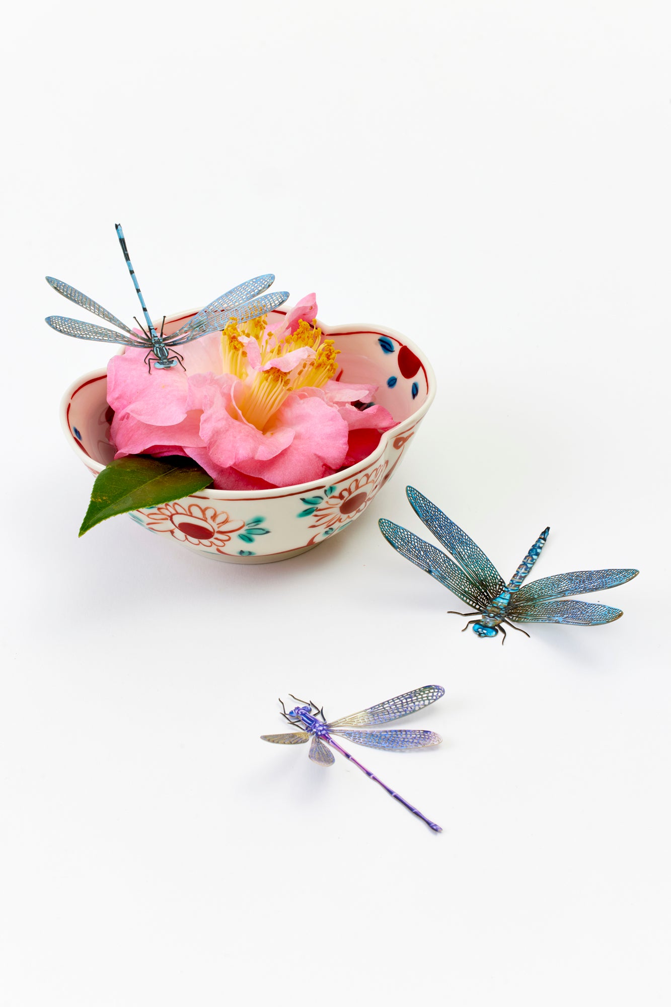 Delicately cut paper dragonfly replicas.