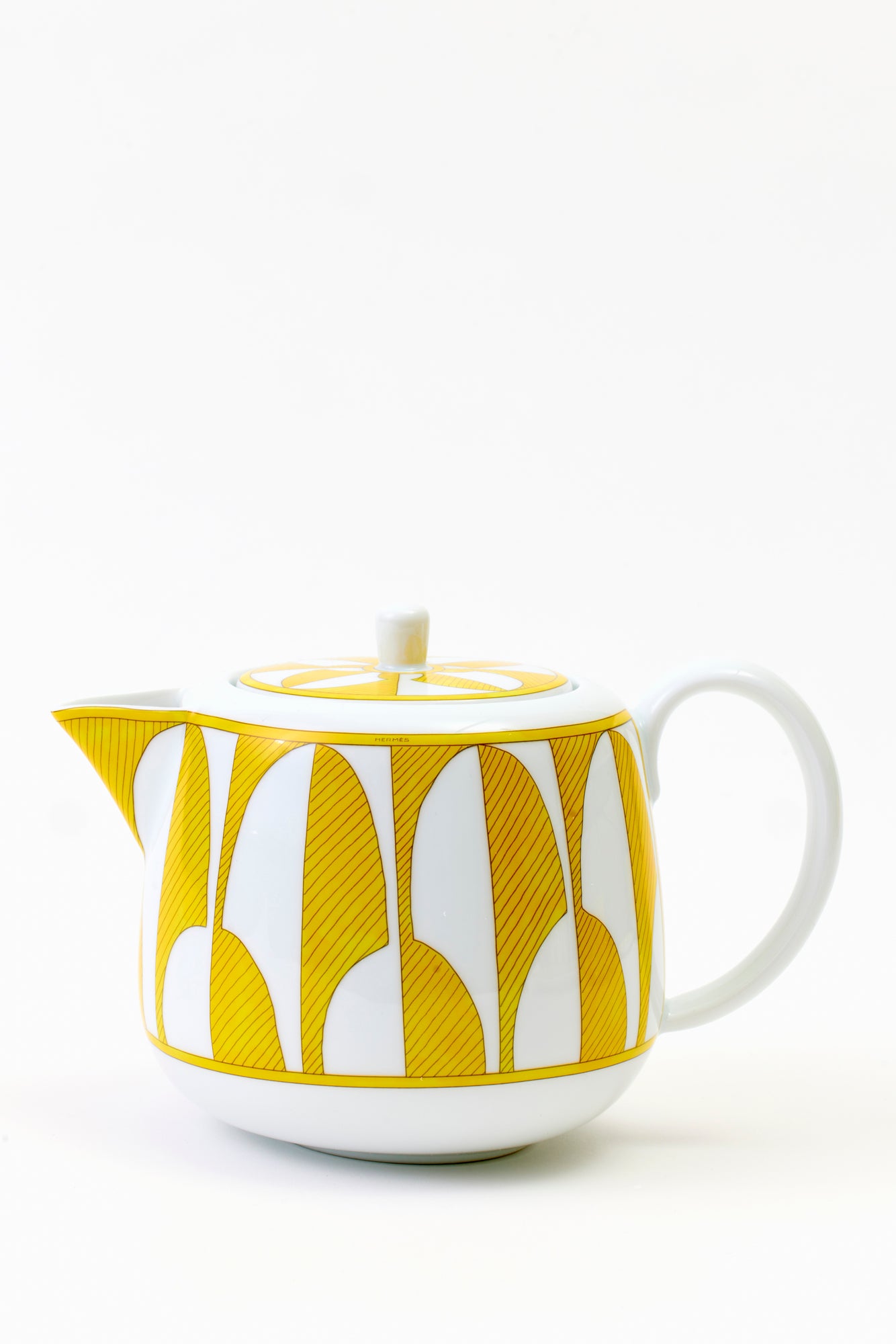 This architectural design by Arielle de Brichambaut for Hermès is intensely ablaze, its graphic forms radiating with warmth. The subtle variation in shades of yellow and the cross-hatched contours give depth to this ode to summer. Convivial, carefree, and even more beautiful in person - just like you. Fine porcelain. Made in France.
