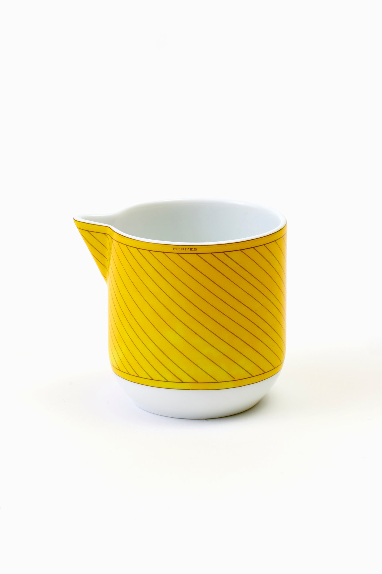 This architectural design by Arielle de Brichambaut for Hermès is intensely ablaze, its graphic forms radiating with warmth. The subtle variation in shades of yellow and the cross-hatched contours give depth to this ode to summer. Convivial, carefree, and even more beautiful in person - just like you. Fine porcelain. Made in France.