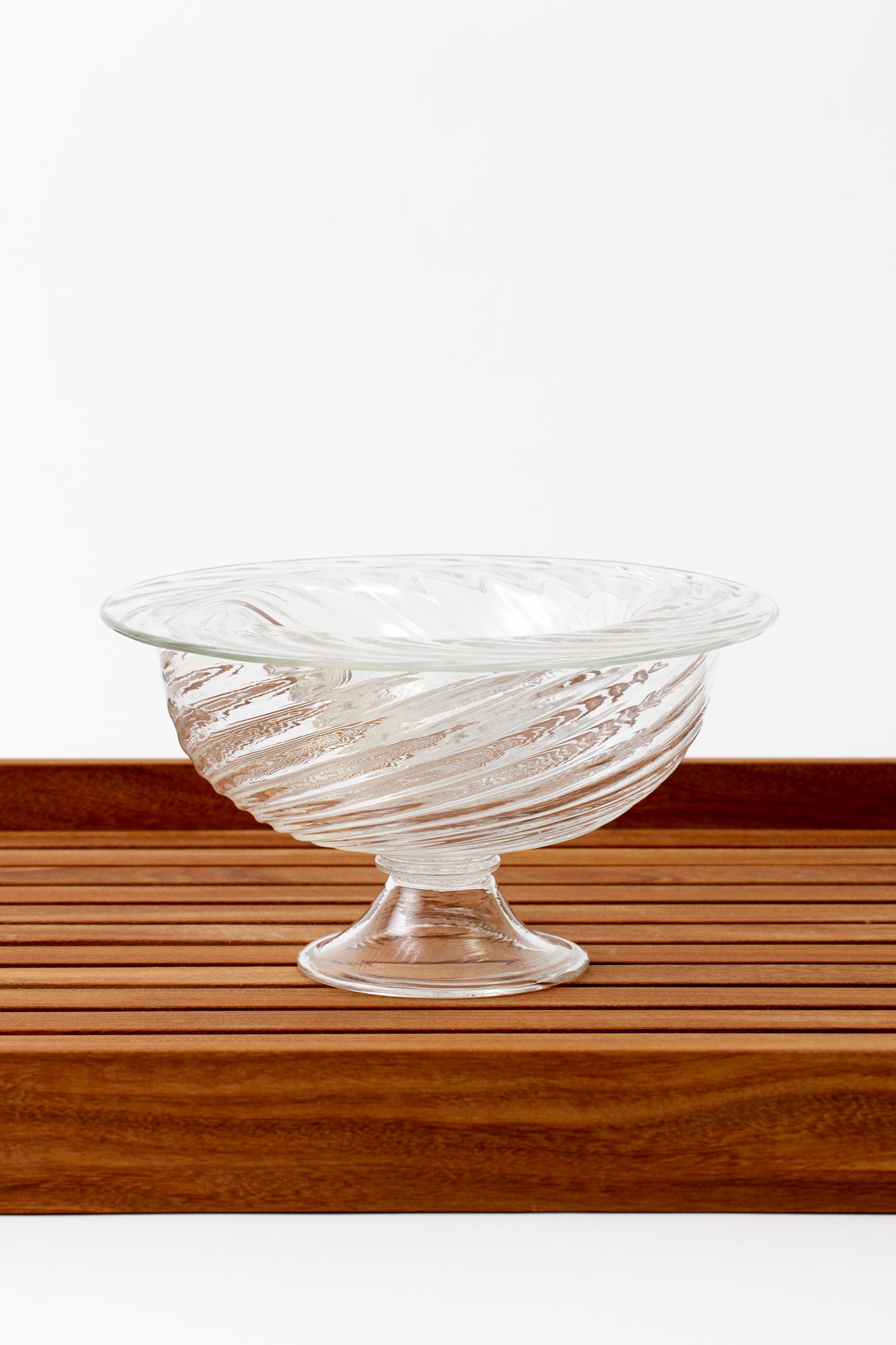 Party-sized artisanal twisted handblown glass caviar service, filled with black caviar and resting on a silver platter with glass caviar spoons.