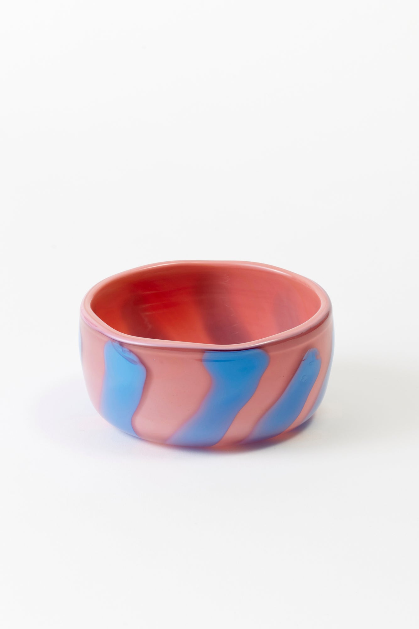Hand-blown glass candy dishes by Paul Arnhold that is pink with blue stripes.