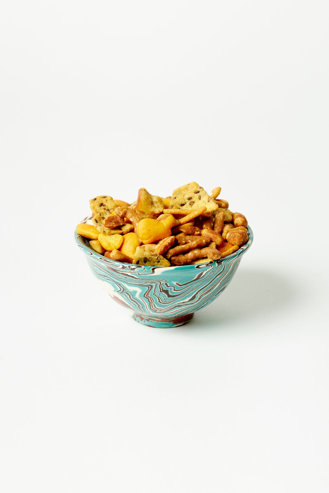 Marbled ceramic snack bowl filled with pub snack mix.