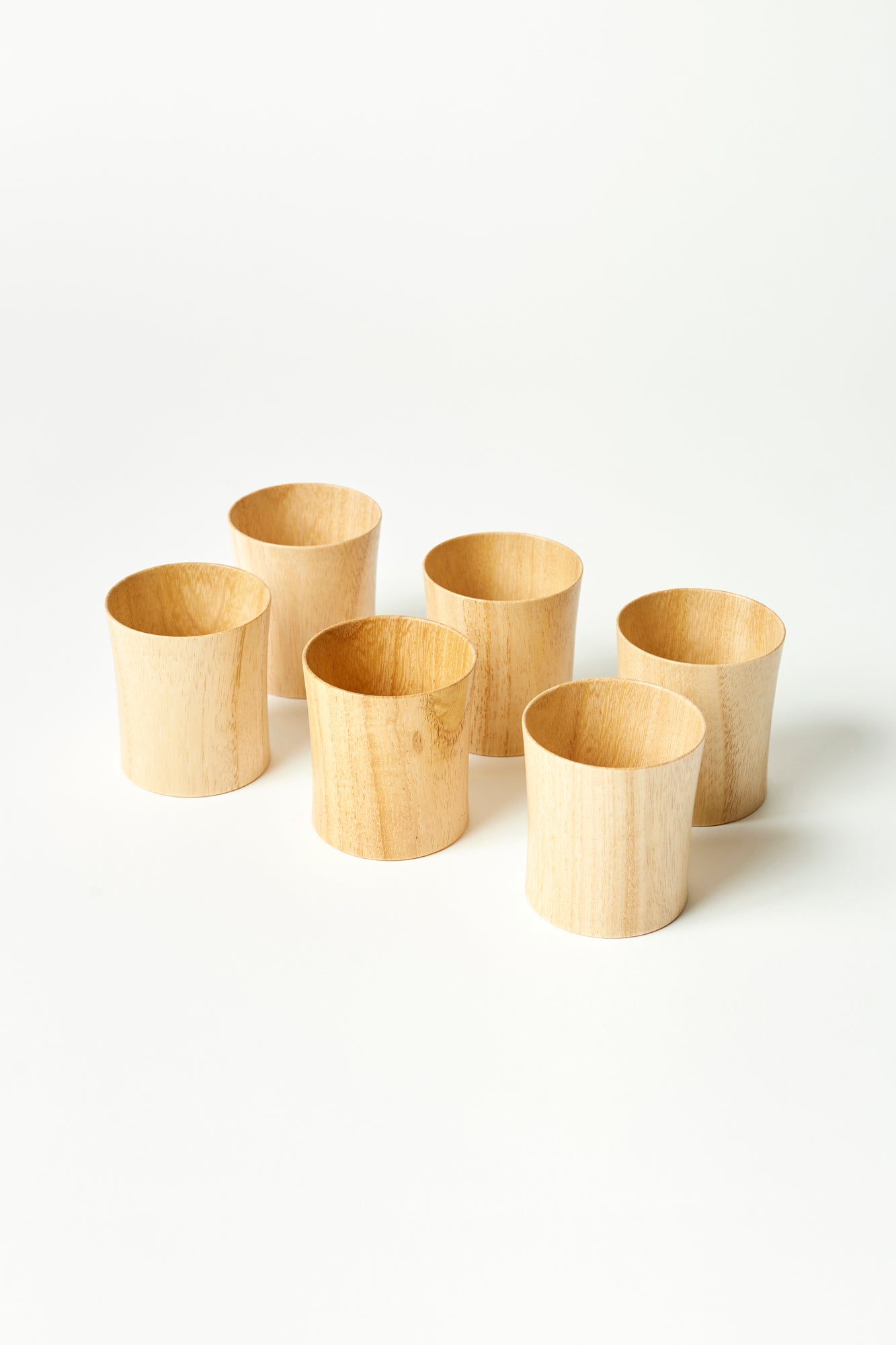 Six wooden tumblers made from Paulownia wood, photographed against a white background.