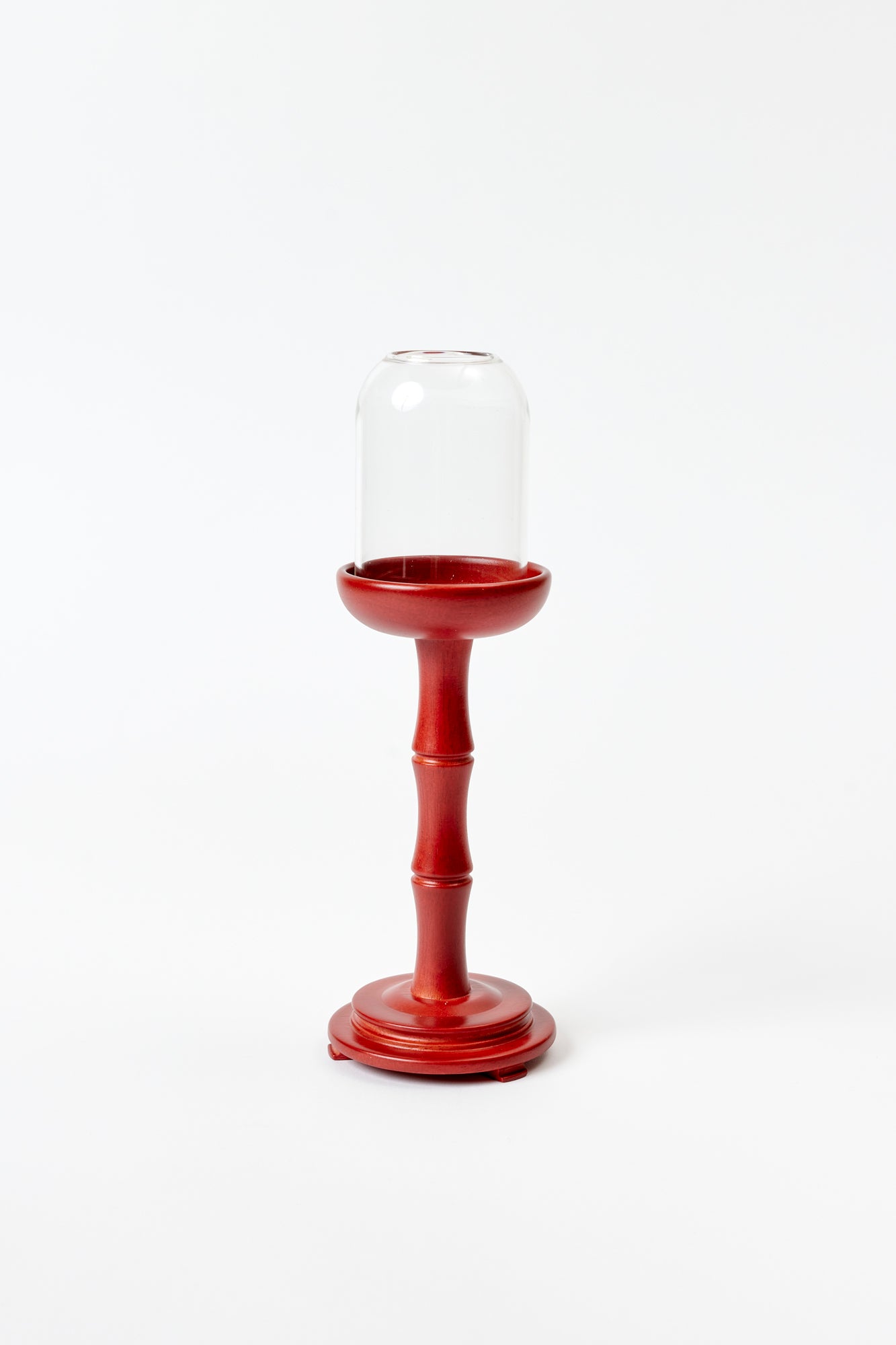 Red table lamp base with glass votive holder photographed against a white background.