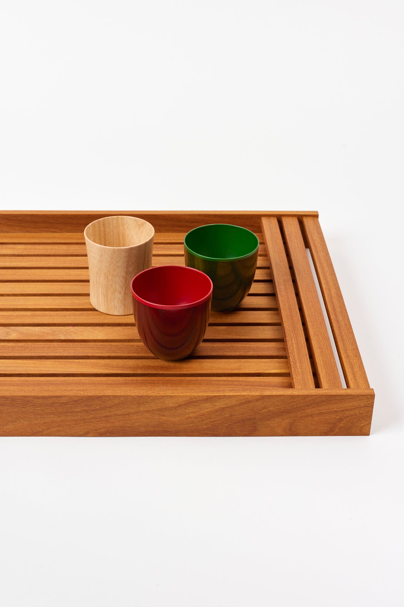 Tumbler on a wooden passing tray against a white background.