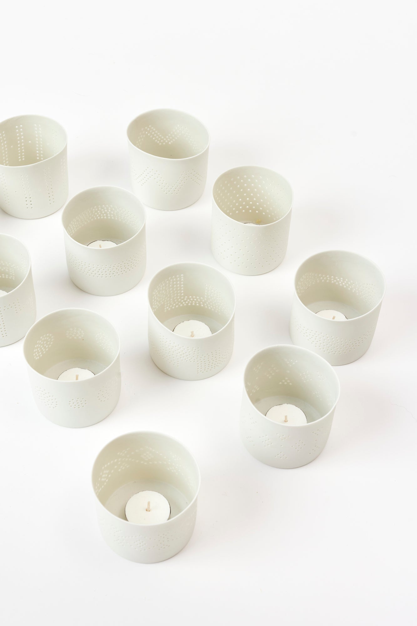 Porcelain bisque votives are sculpted and pierced by hand in France.