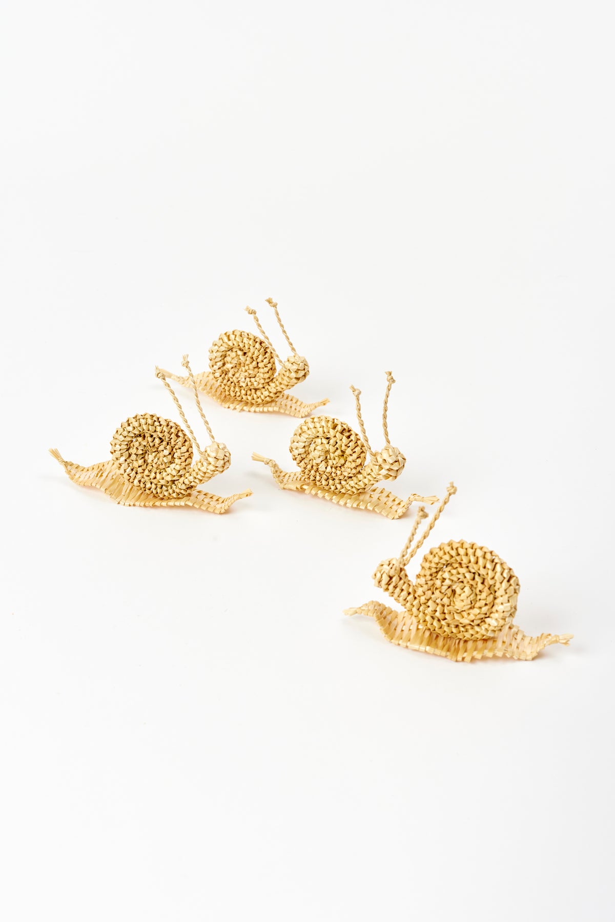 4 snails made of corn husks against a white background. Each snail is 5” length x 1.25” width x 2” height.