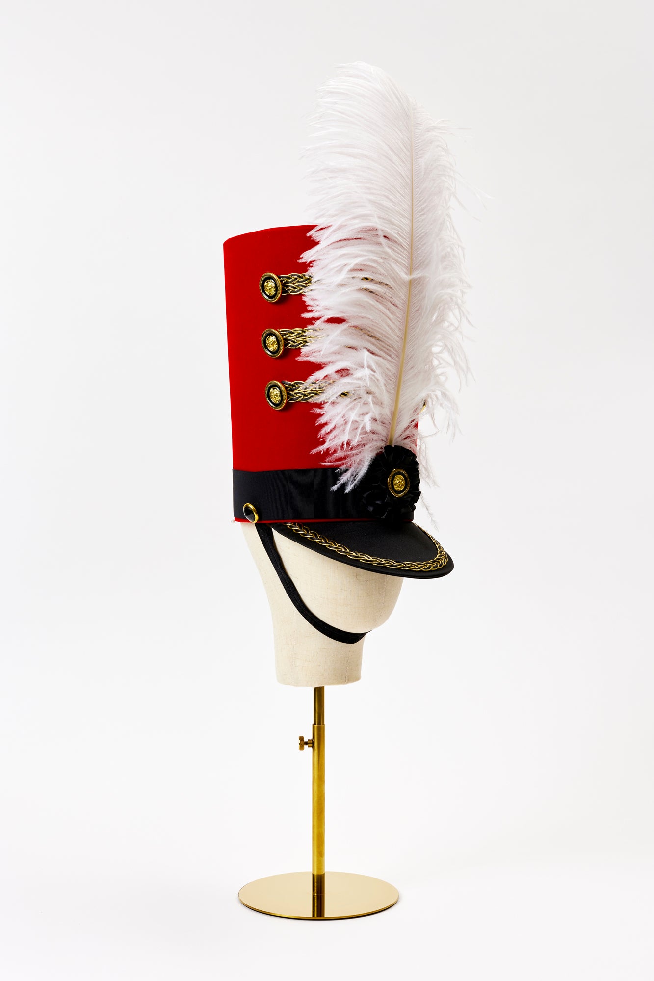 Drum major hat that is tall and red.