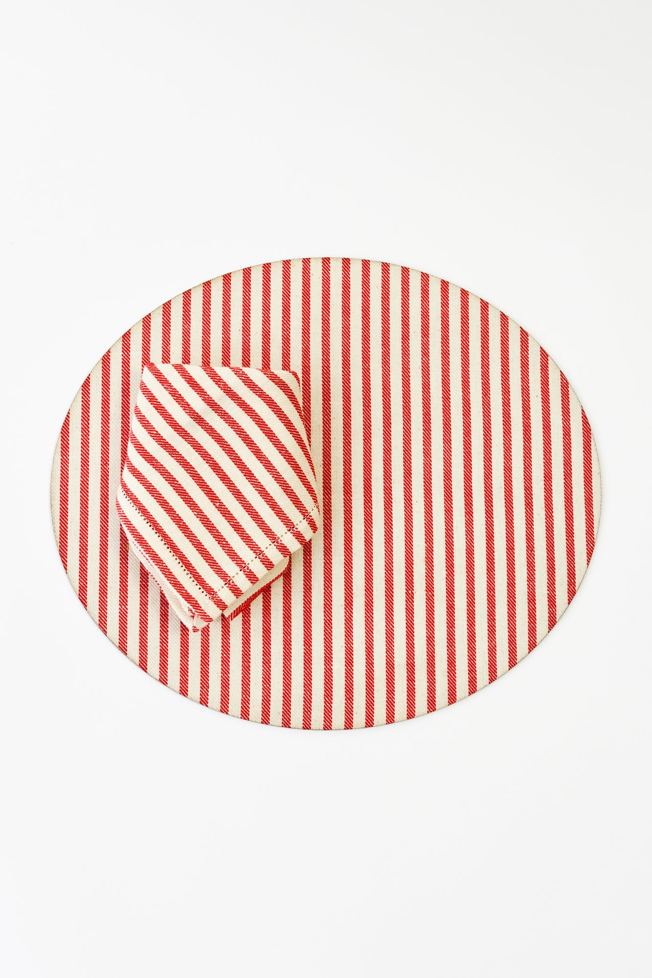 Round placemat with red and cream vertical stripes, adding a classic and elegant touch to any table setting.