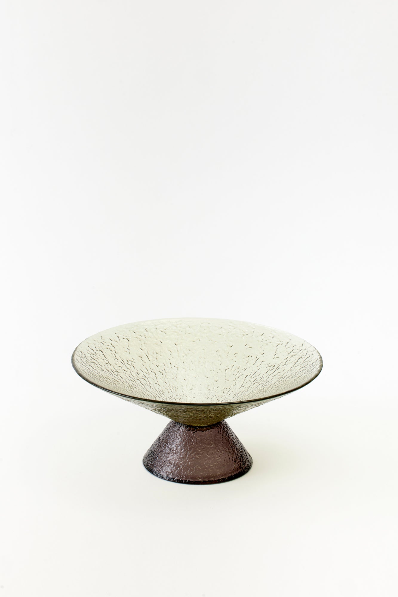 Minimalist green pedestal dish with a textured glass surface, perfect for adding a touch of modern elegance to any table setting.