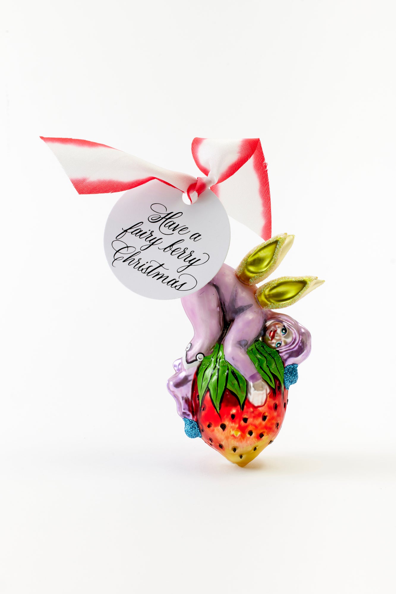 Hand-painted fairy on a strawberry glass ornament crafted in Poland.