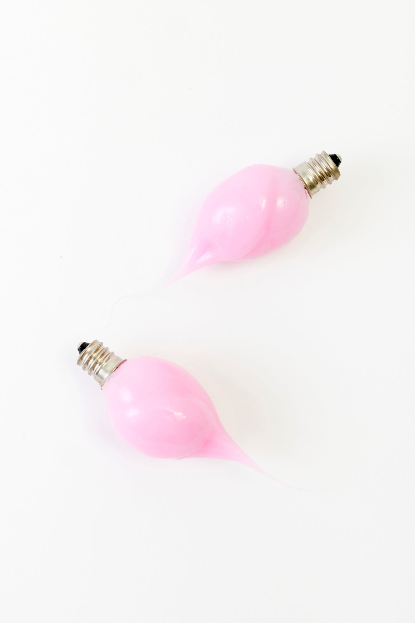 Futuristic elegance meets artistic design with these blush-pink, sculpted light bulbs. Their organic teardrop shape and glossy finish make them a captivating accent for any avant-garde space.