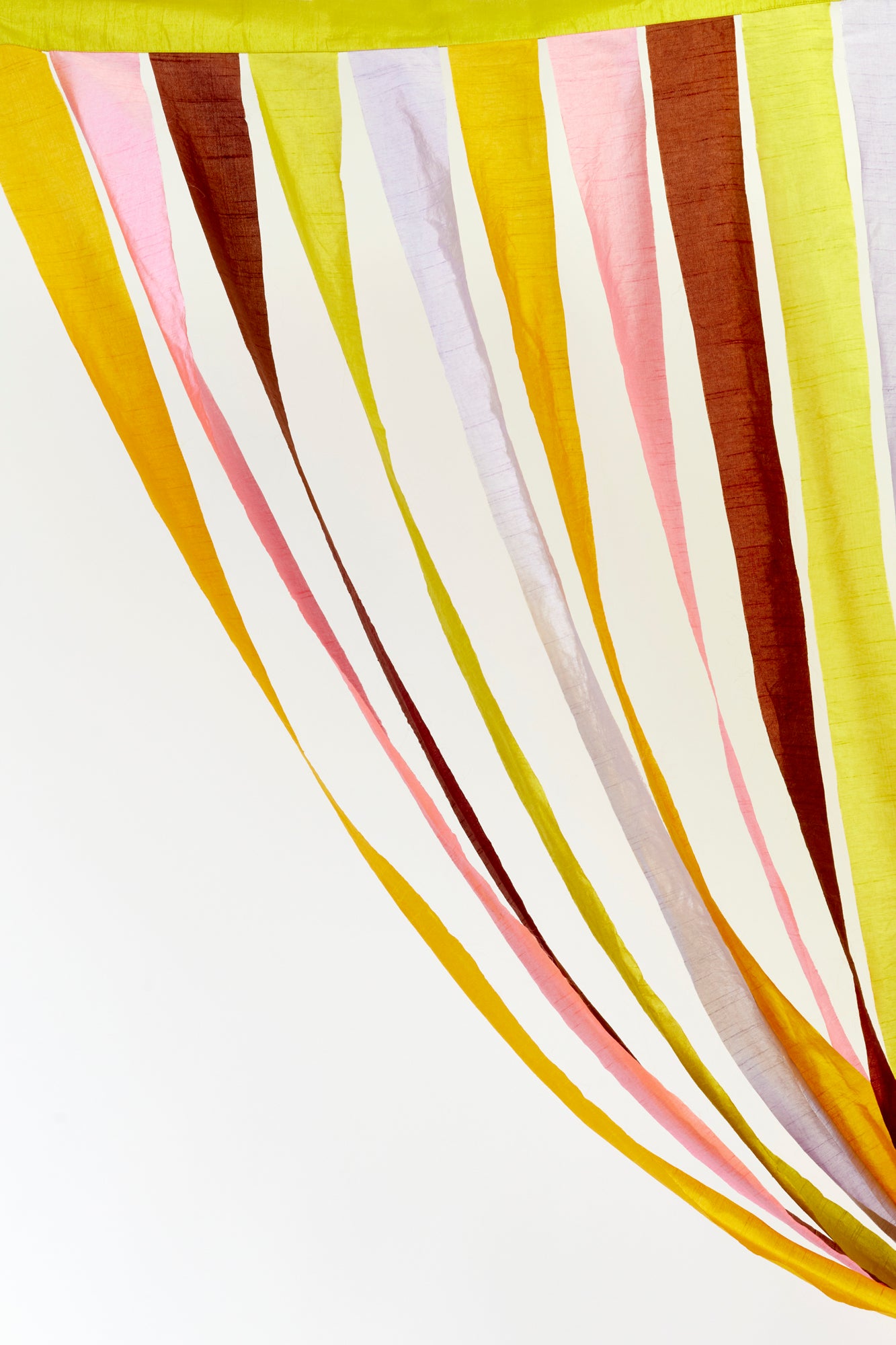 Dynamic, multicolored fabric strips in shades of yellow, pink, brown, and white, elegantly flowing from above. These bold, festive drapes bring a cheerful and artistic flair to any stylish celebration.