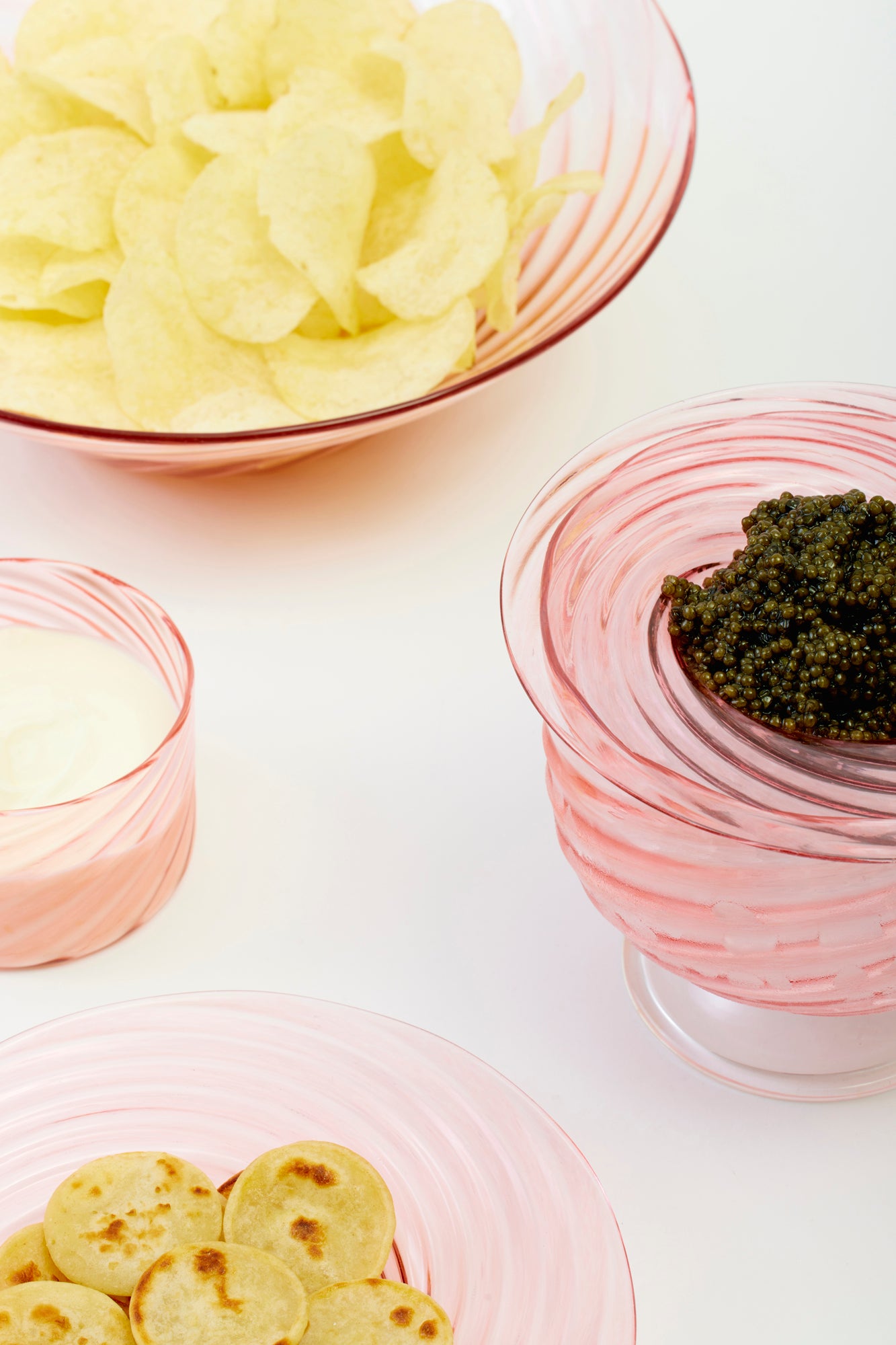 Close up of artisanal twisted glass caviar service in blush, handblown by Tracy Glover in her Rhode Island studio.