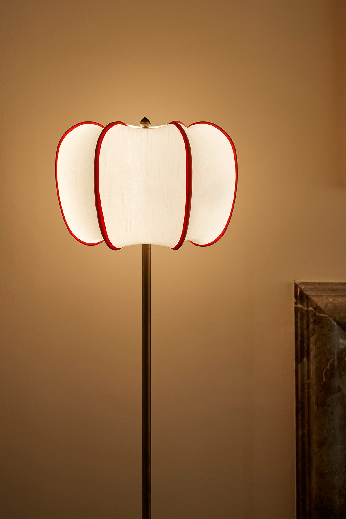 Chic and timeless, this floor lamp features a soft, ivory fabric shade trimmed in striking red accents, evoking both modernity and vintage charm. The red tassel detail completes the refined aesthetic, making it an ideal piece for an upscale living space.