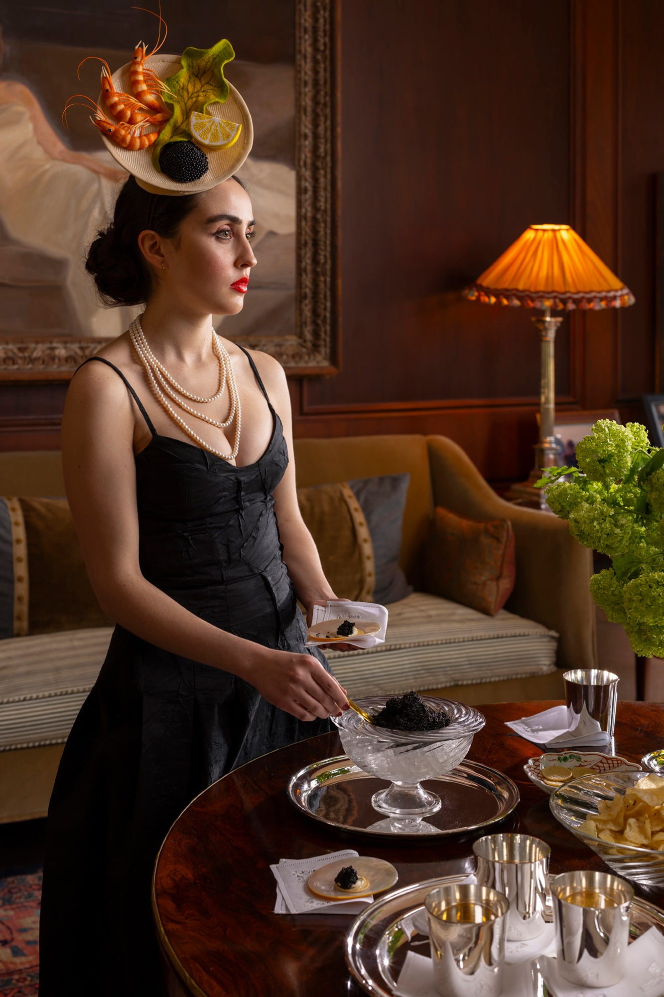 Party-sized artisanal twisted handblown glass caviar service, filled with black caviar and resting on a silver platter with glass caviar spoons.
