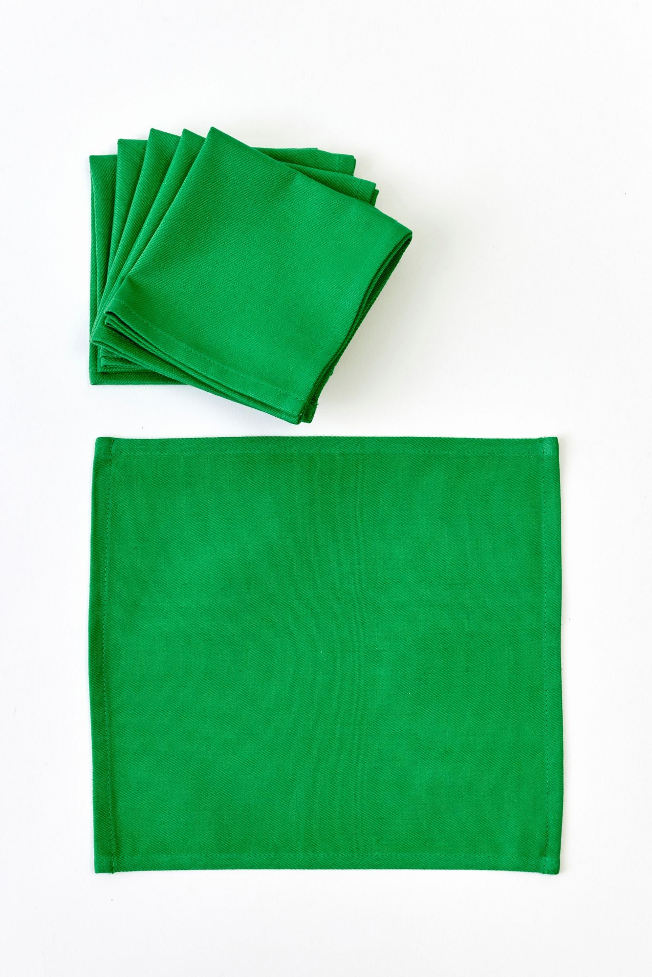 Stack of green napkins on a white background