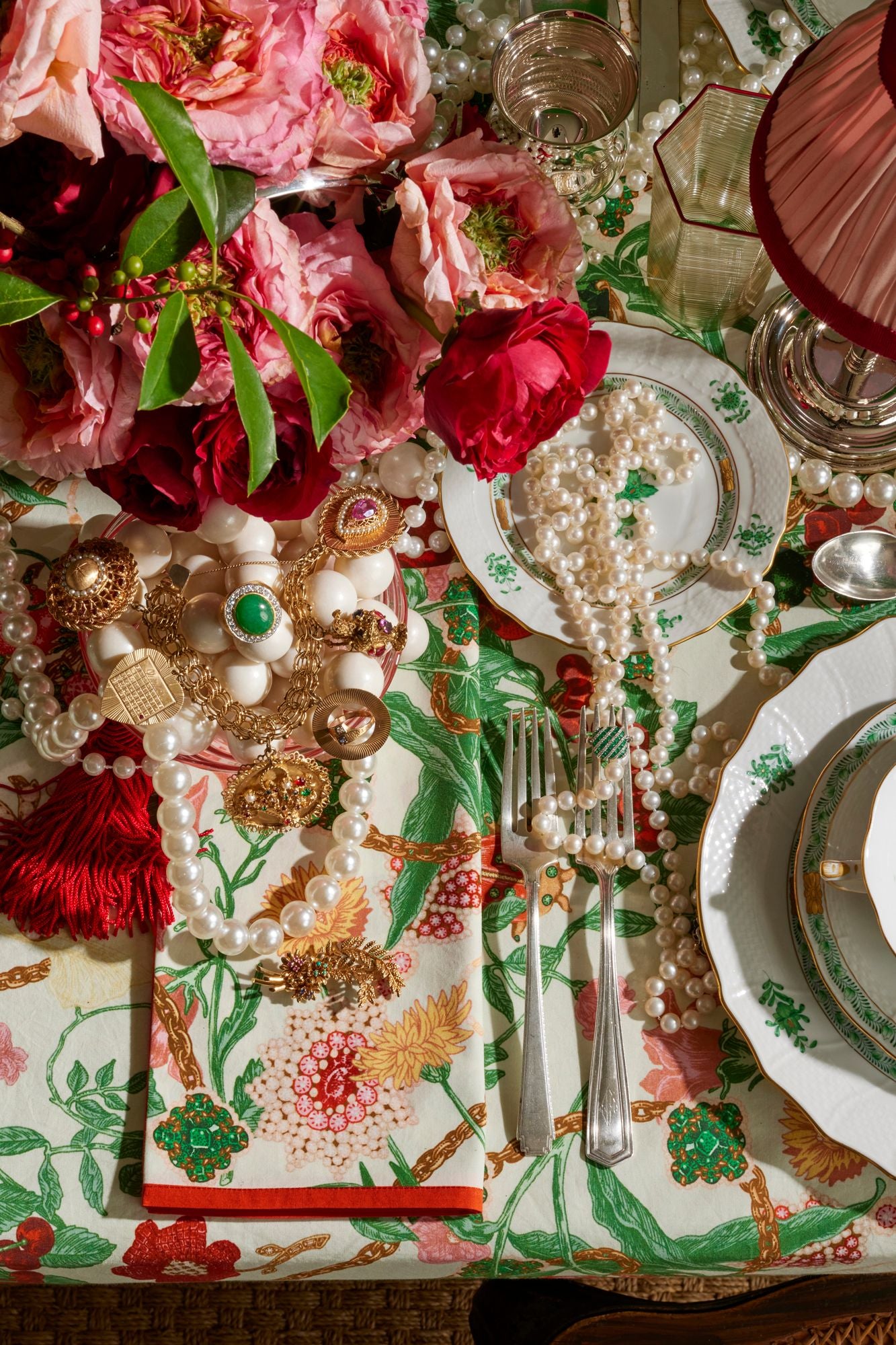 Decorative table setting with flowers, jewelry, and patterned tablecloth.