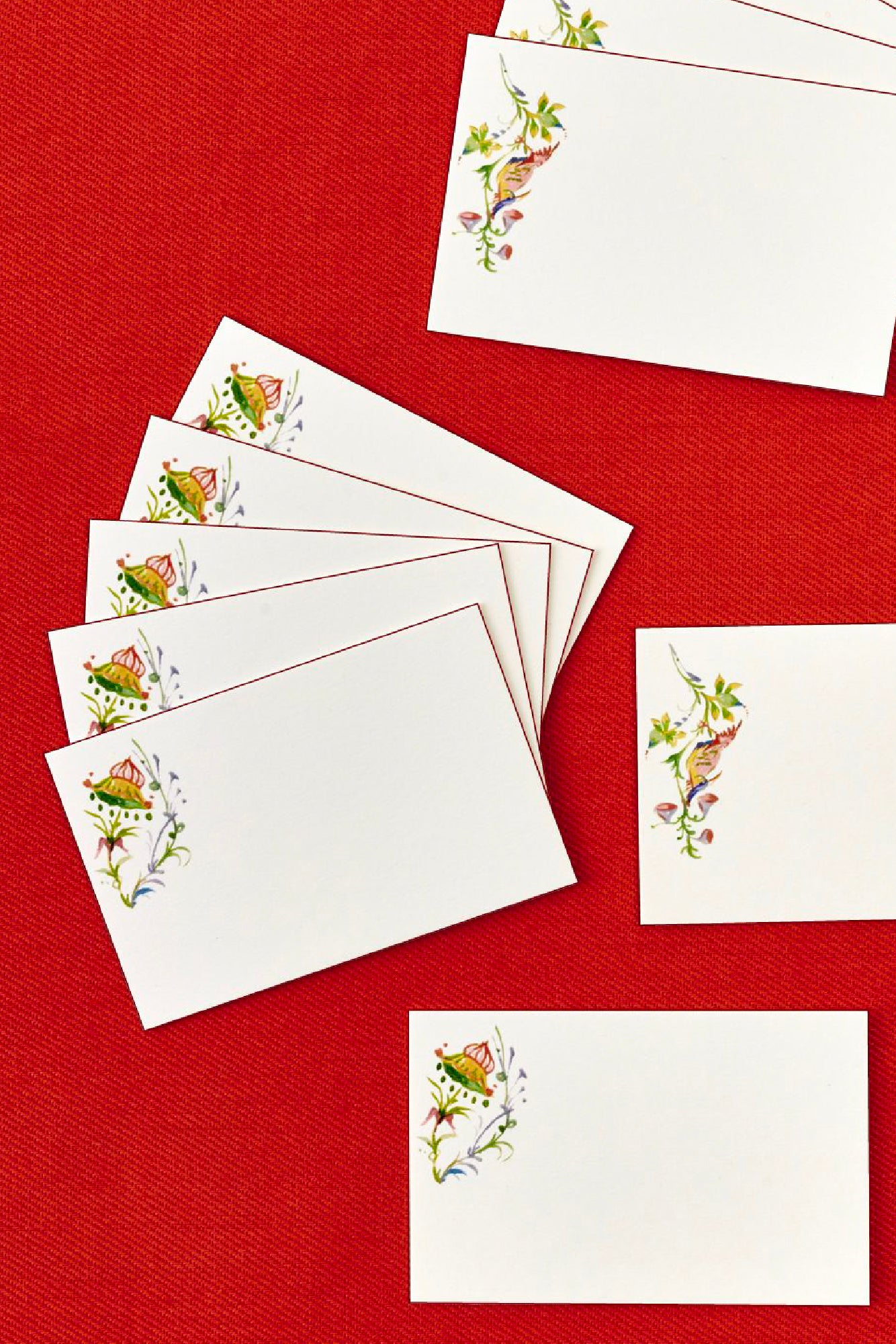 White cards with floral designs on a red background