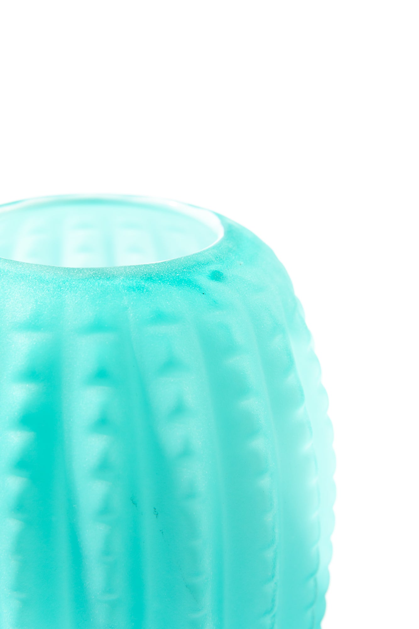 Detail photograph of top of blue vintage vase against white background. Frosted teal glass with a ribbed pattern around.