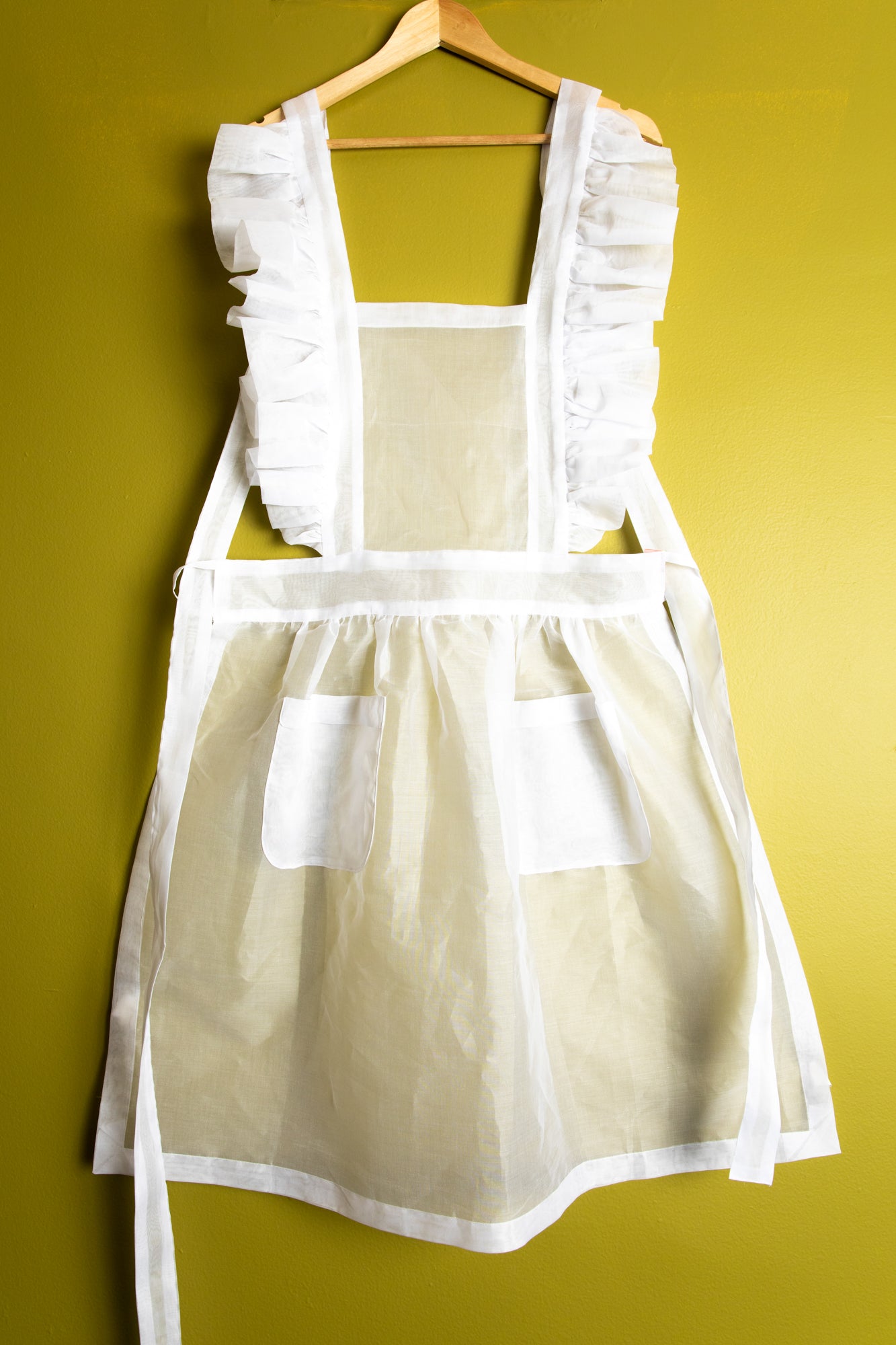 Charming ruffled aprons in white cotton organdy.