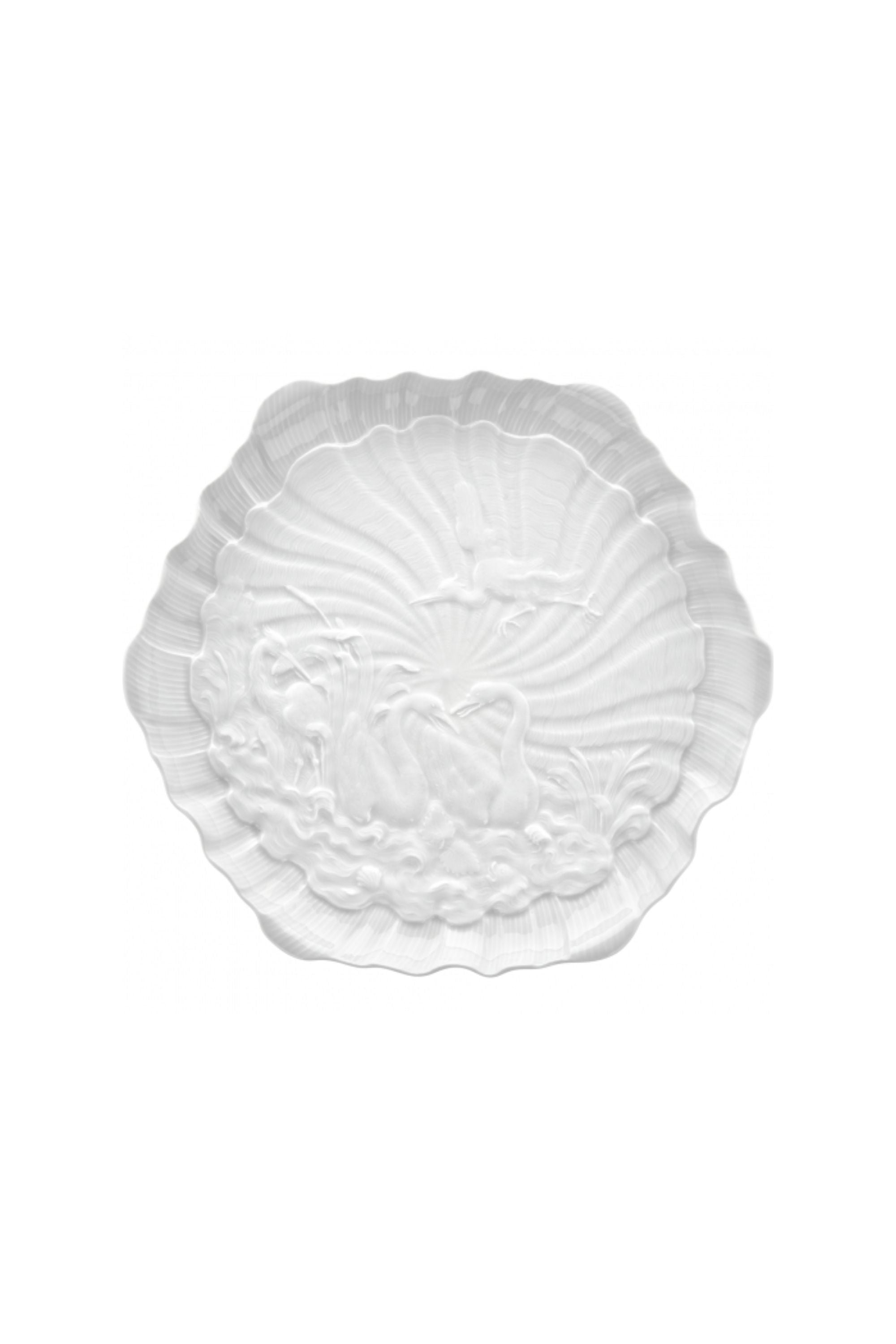 Designed by Johann Joachim Kändler, the pattern features a delicate background with radiating bands based on a scallop shell and a central well dressed with a pair of swans on water amid bullrushes, swooping cranes, and fish. Several parts of the service depict figures from Greco-Roman mythology, like Glaucus and the dolphin-riding Galatea.