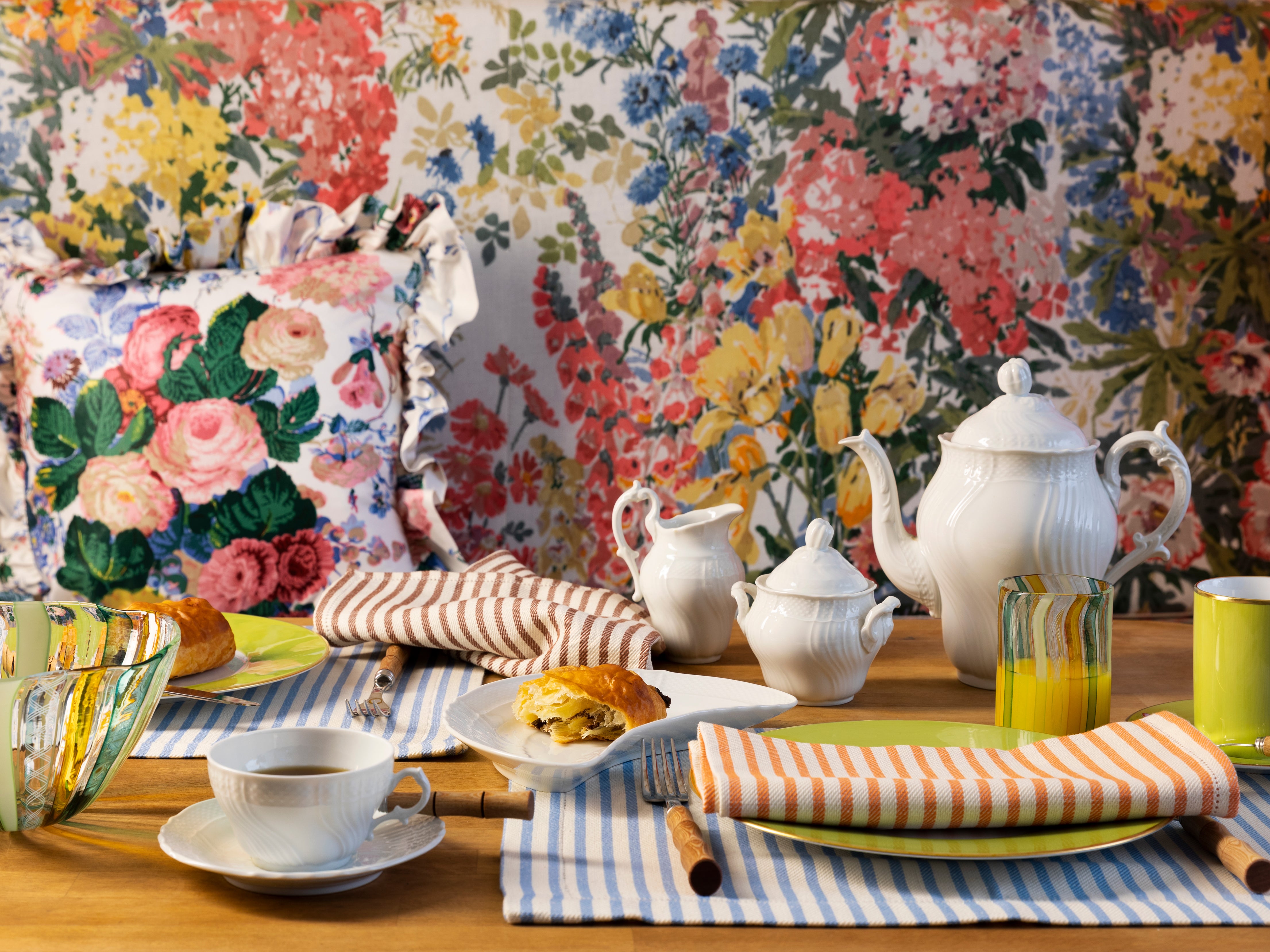 Tabletop with striped linens and white porcelain tea service.