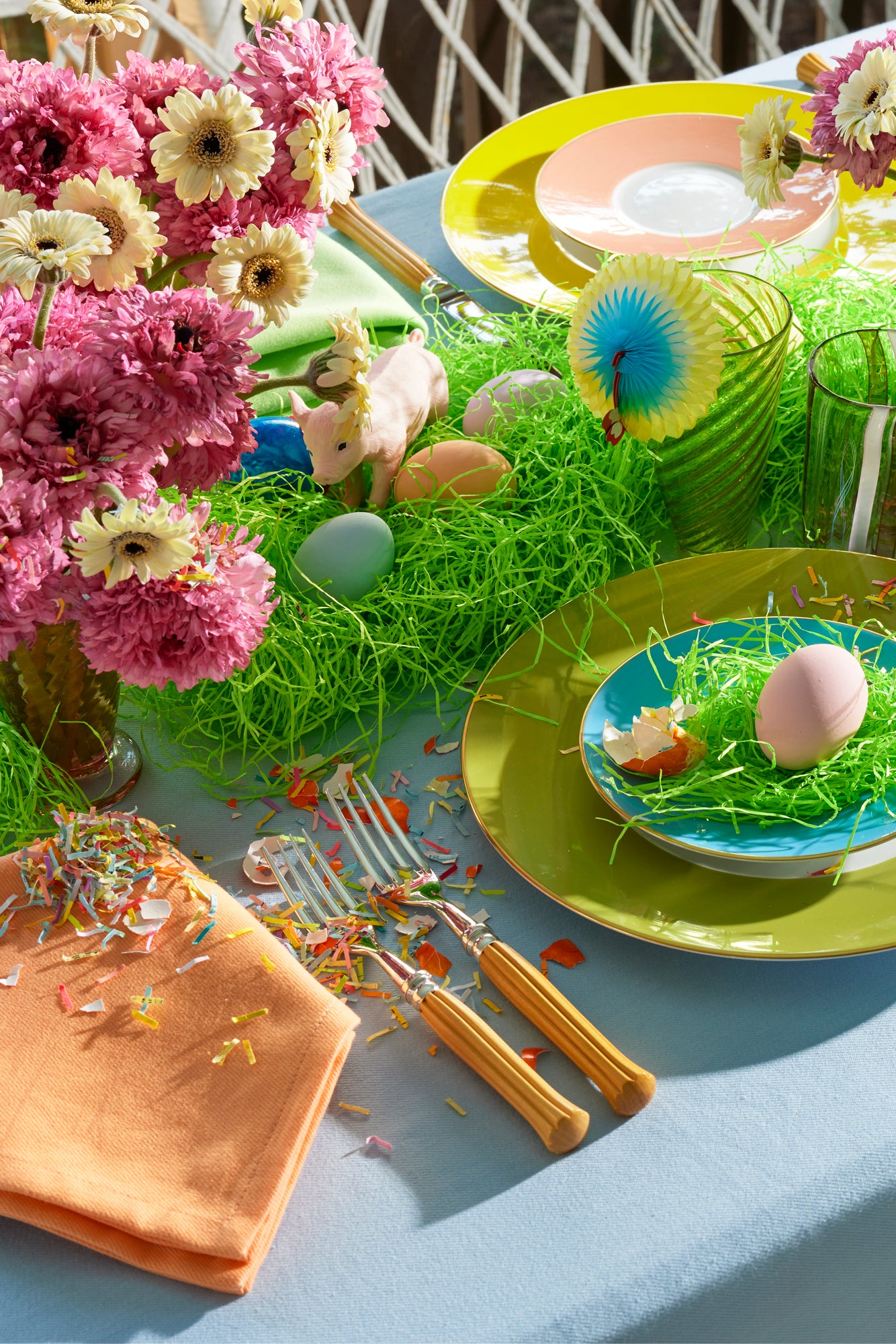 Carton of a colorful dozen eggs with confetti in them.