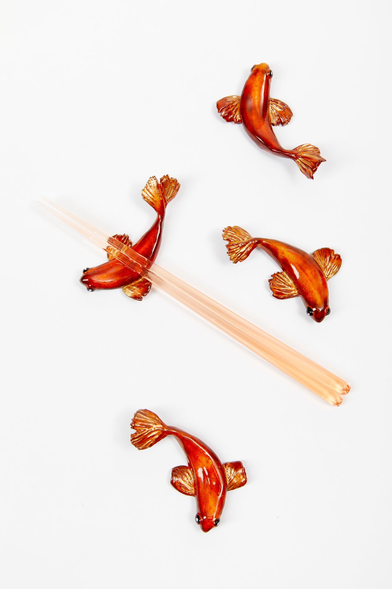 Handmade and glazed ceramic kois to be used as chopstick rests or figurines.