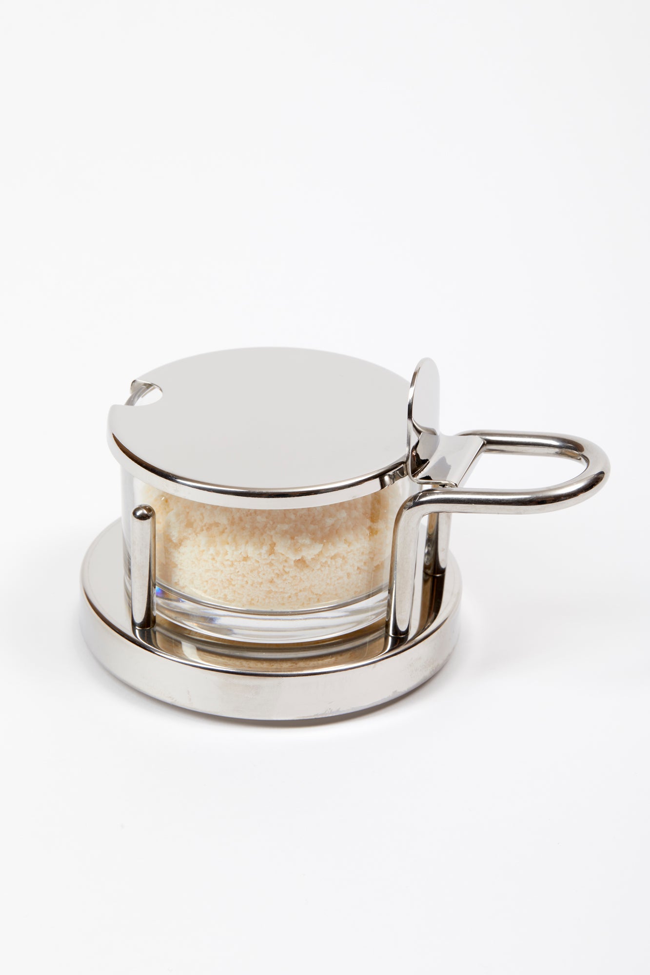 Parmesan Cheese Cellar designed by Ettore Sottsass in 1978. This is an elegant serving piece with a clear glass bowl set in a mirror-polished 18/10 stainless steel holder.