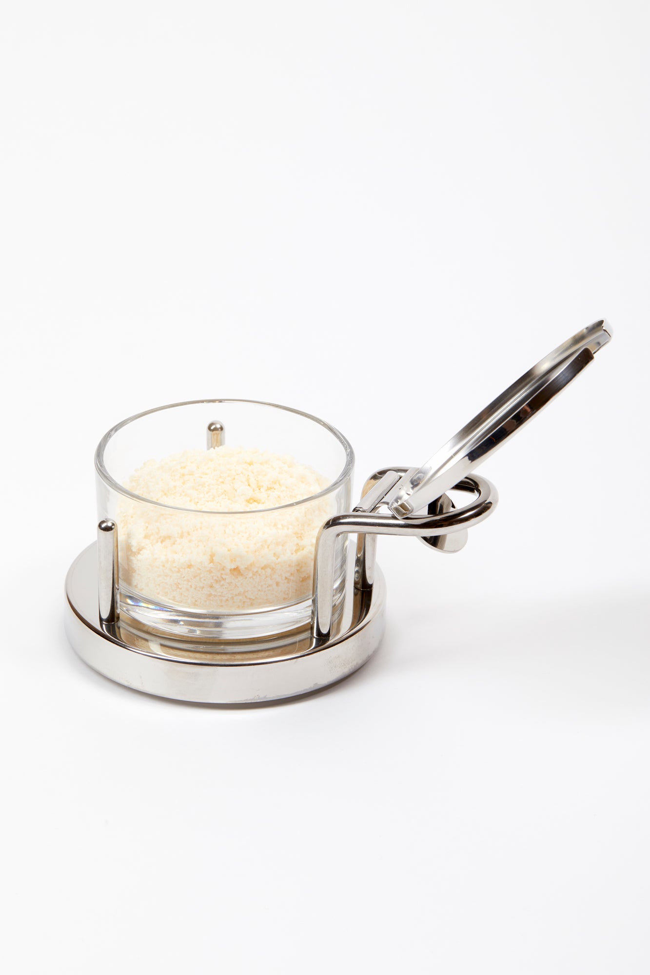 Parmesan Cheese Cellar designed by Ettore Sottsass in 1978. This is an elegant serving piece with a clear glass bowl set in a mirror-polished 18/10 stainless steel holder.