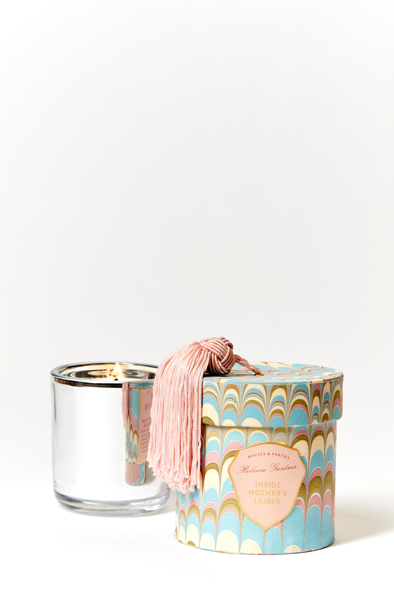 Glamorous silver glass candles come in boxes wrapped with our signature artisan marbled paper and crowned with a sumptuous blush tassel.