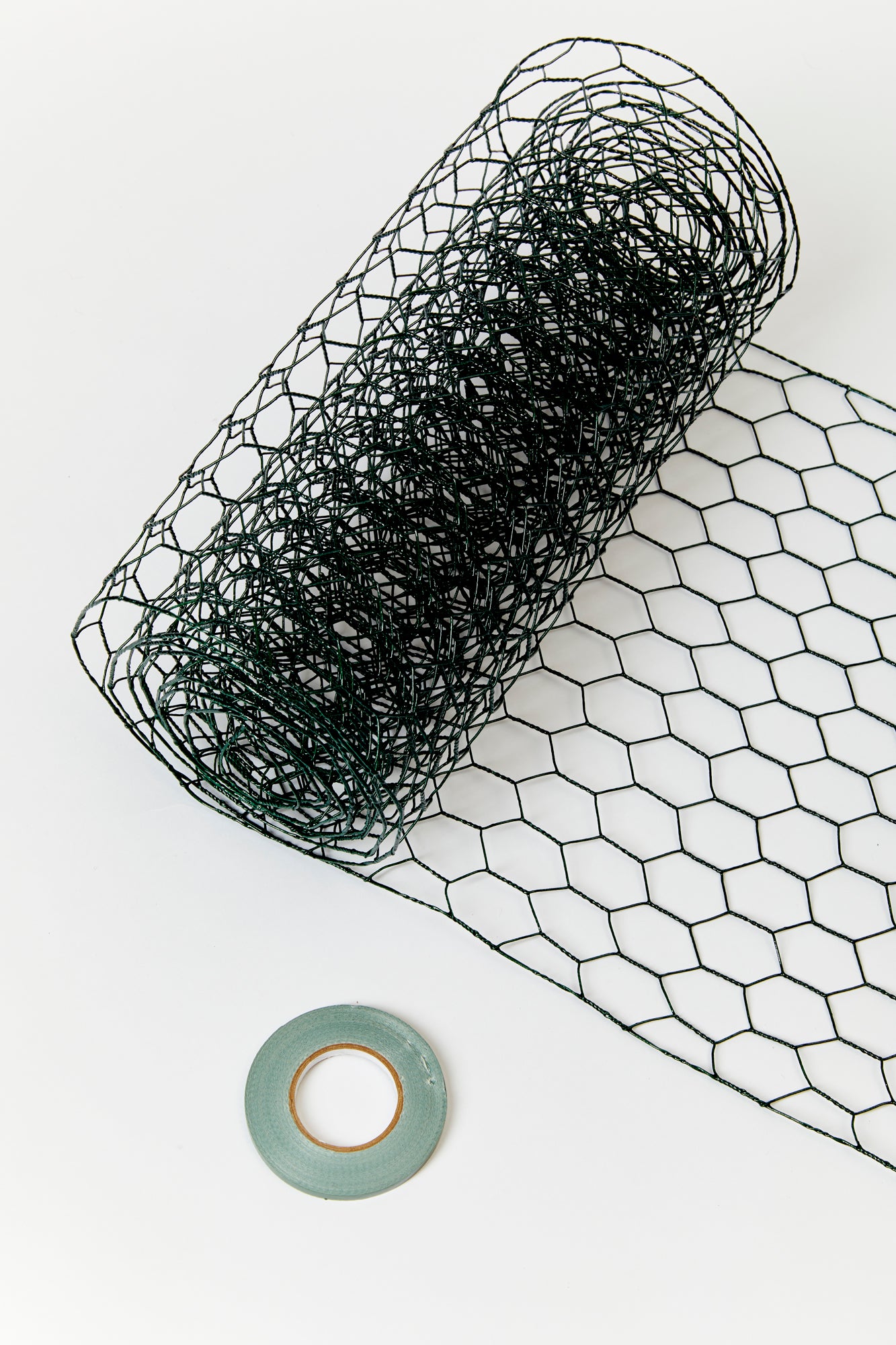 The essential tools for creating floral arrangements: floral netting, tape and scissors.