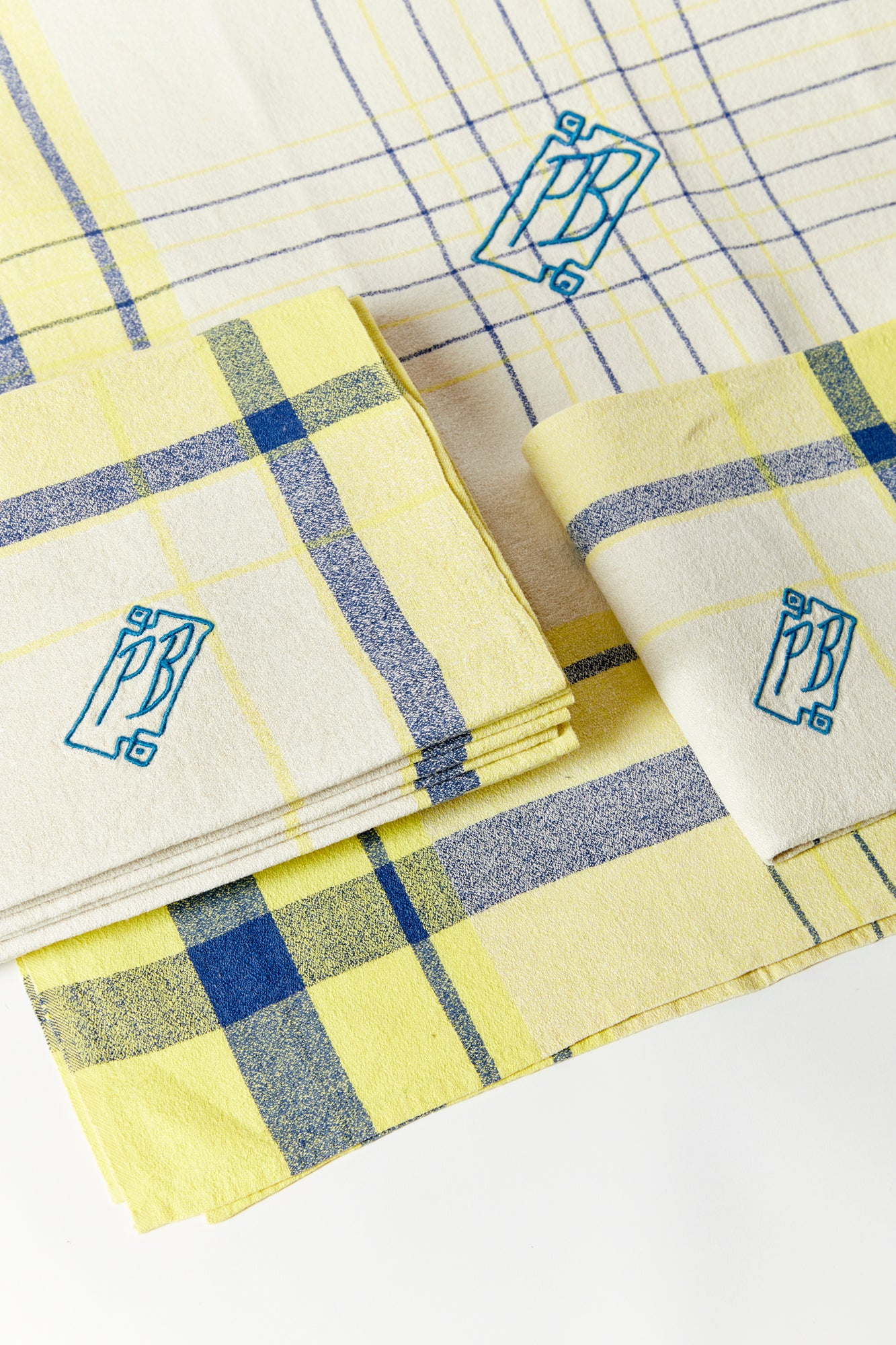 Set of plaid napkins and tablecloth with the letters PB embroidered into the fabric.