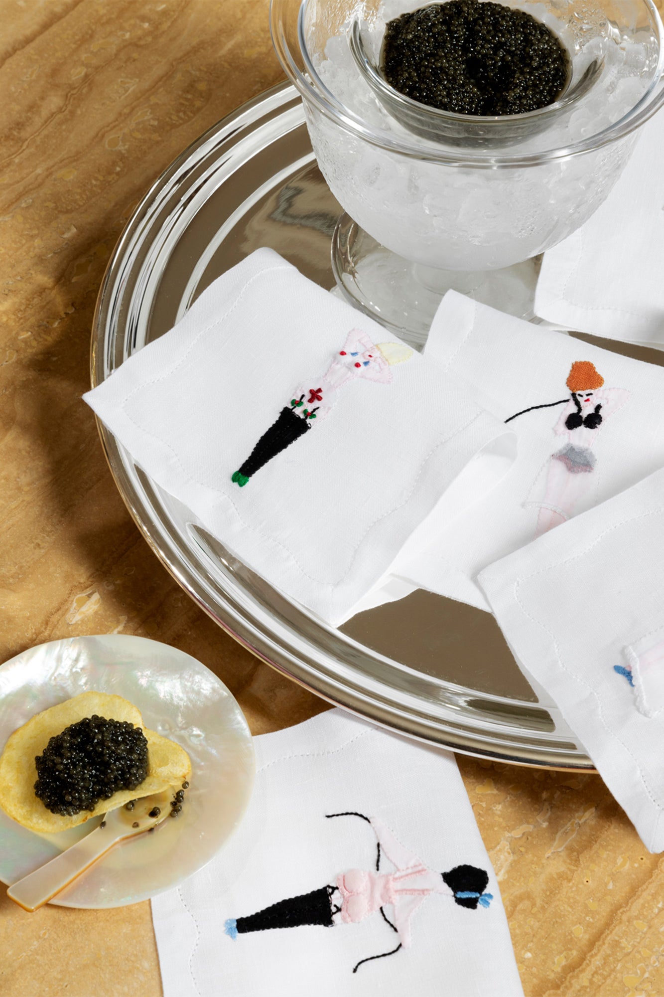 Photograph featuring caviar and mother of pearl plates and spoons.