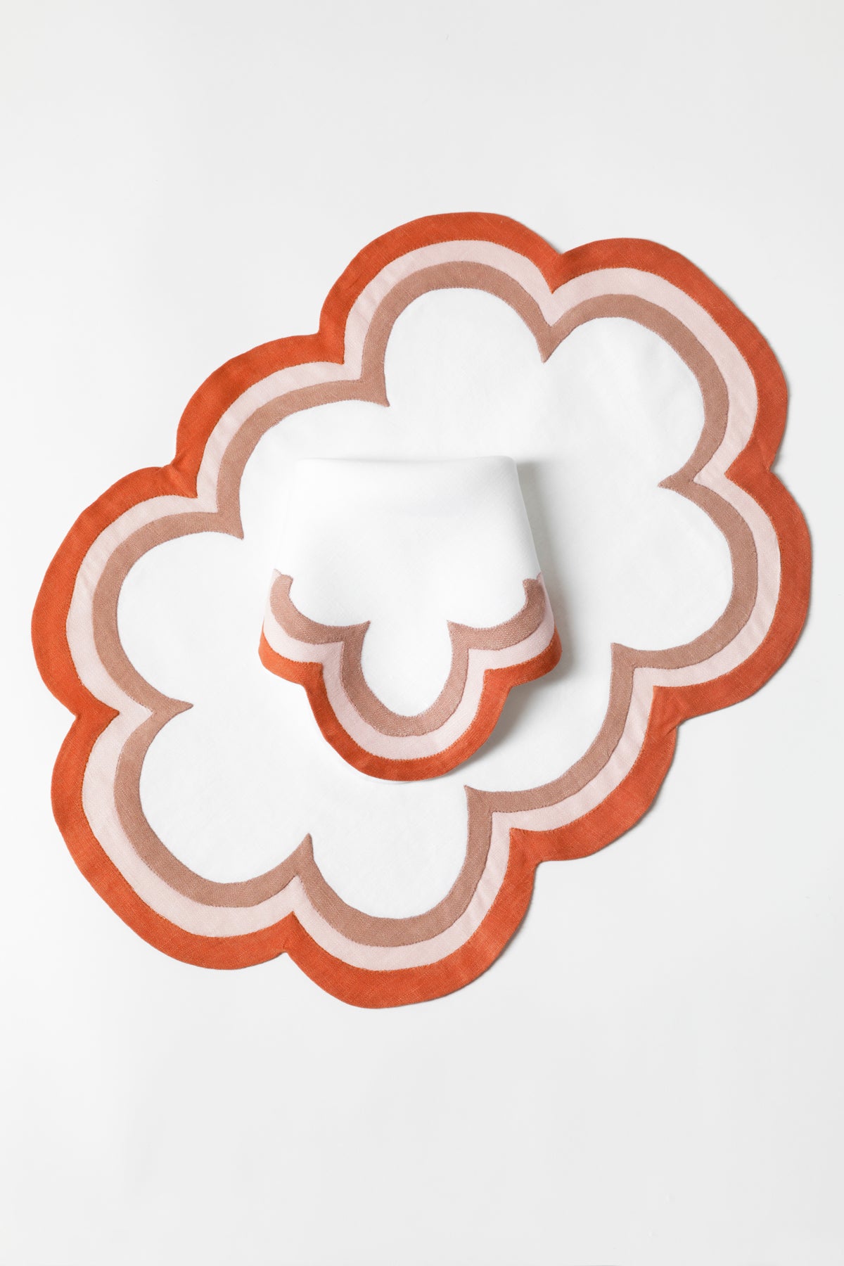 Linen dinner napkins in Persimmon with triple French stitch appliqué scallops made in Madeira, Portugal, exclusively for Houses & Parties.