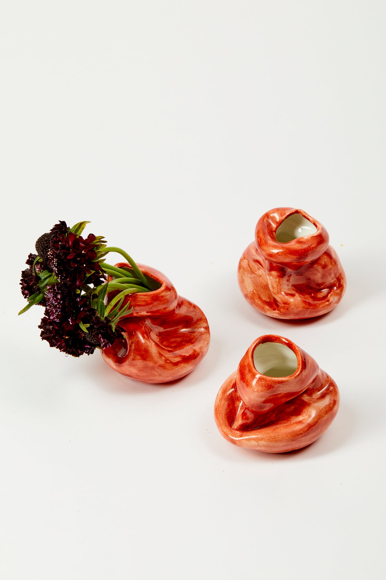 Small red ceramic bud vases.
