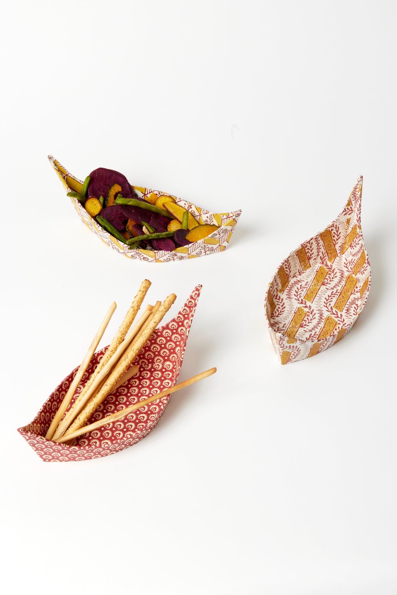 Hand-built cartonnage boat valets in Italian paper inspired by early woodblock prints.