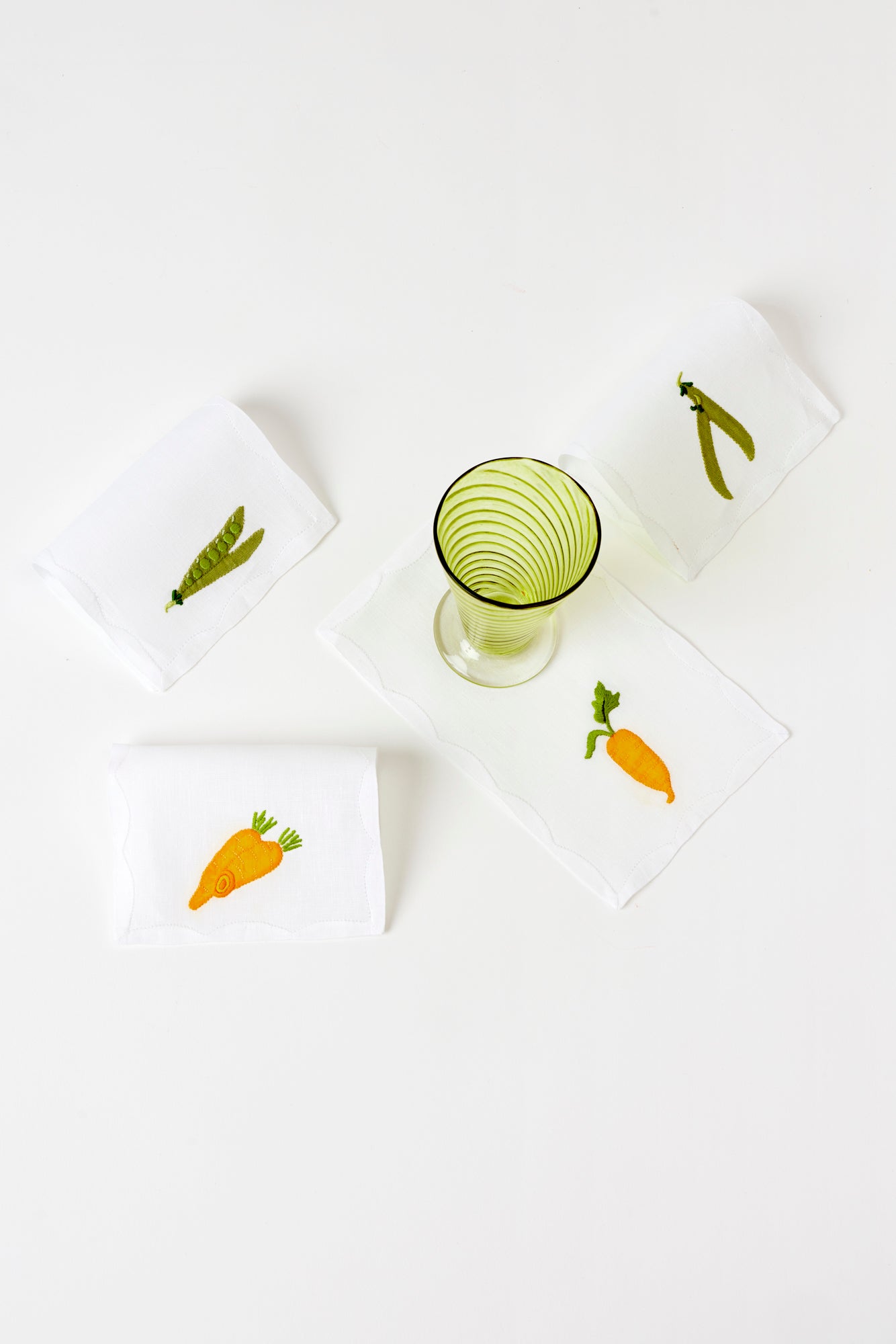 Cocktail napkins embroidered with peas and carrots.