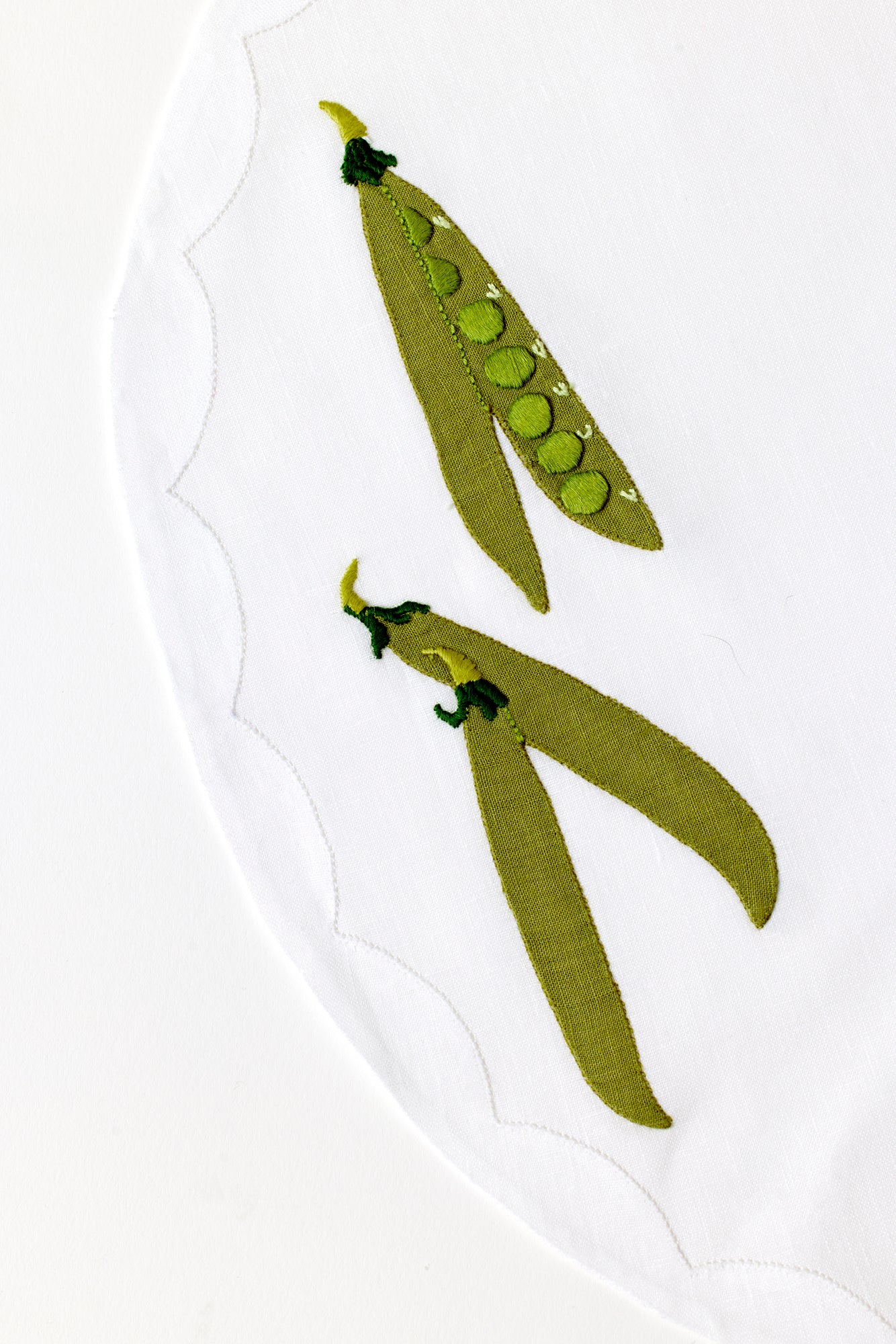 Embroidered pea on linen.